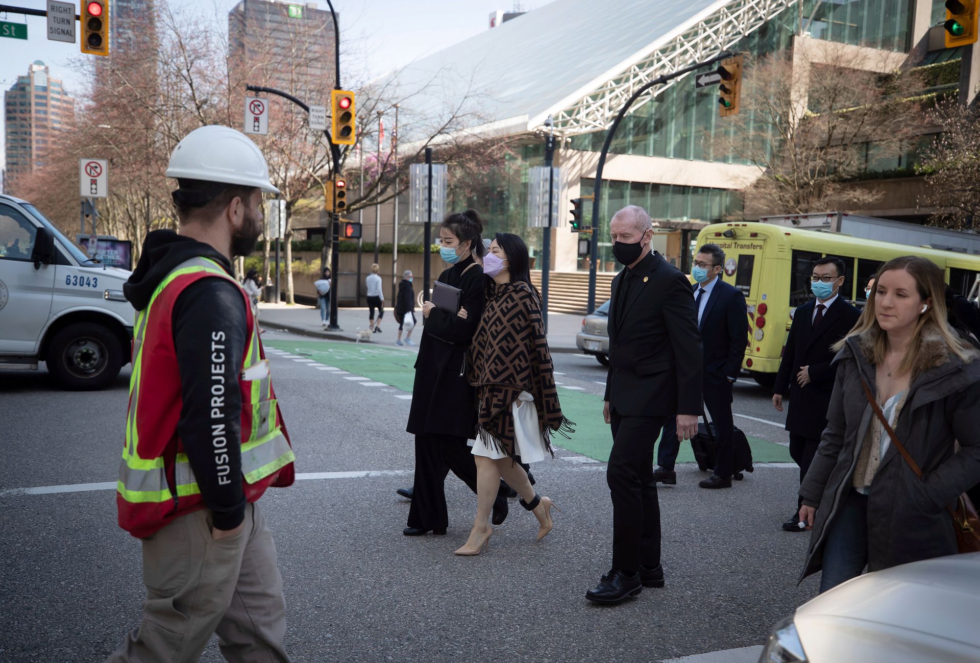 2021年3月31日,孟晚舟在加拿大不列颠哥伦比亚省高等法院举行的引渡听证会休息期间,离开了该法院。孟晚舟身边有多名随行人员。(AP)