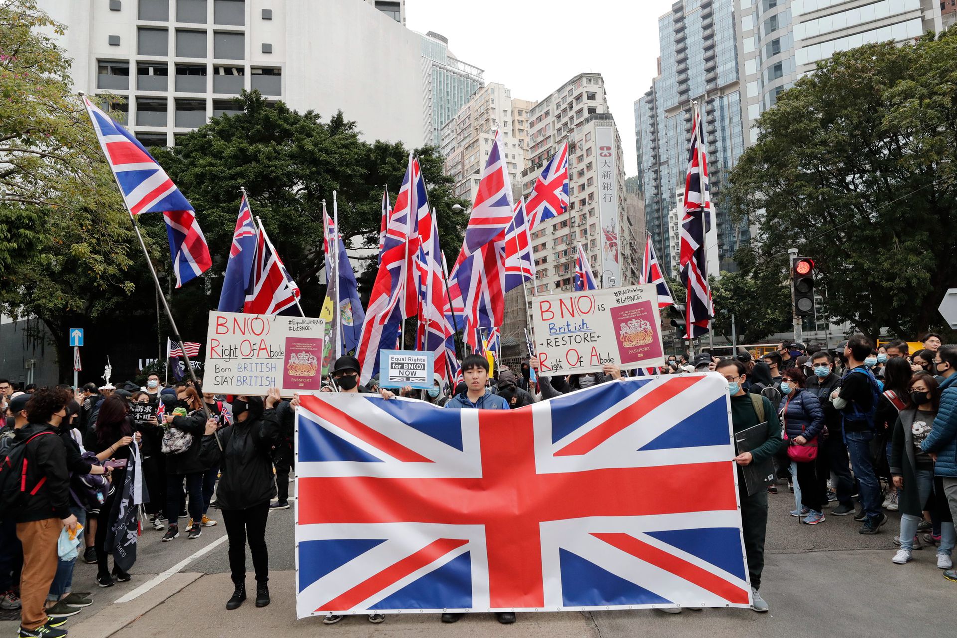 英国首相约翰逊的发言人称，中国政府的举动对1984年签订的《中英联合声明》明显造成威胁，令香港原本享有50年高度自治的地位被终结。图为2020年1月1日，香港的抗议者打着英国国旗游行。（AP）