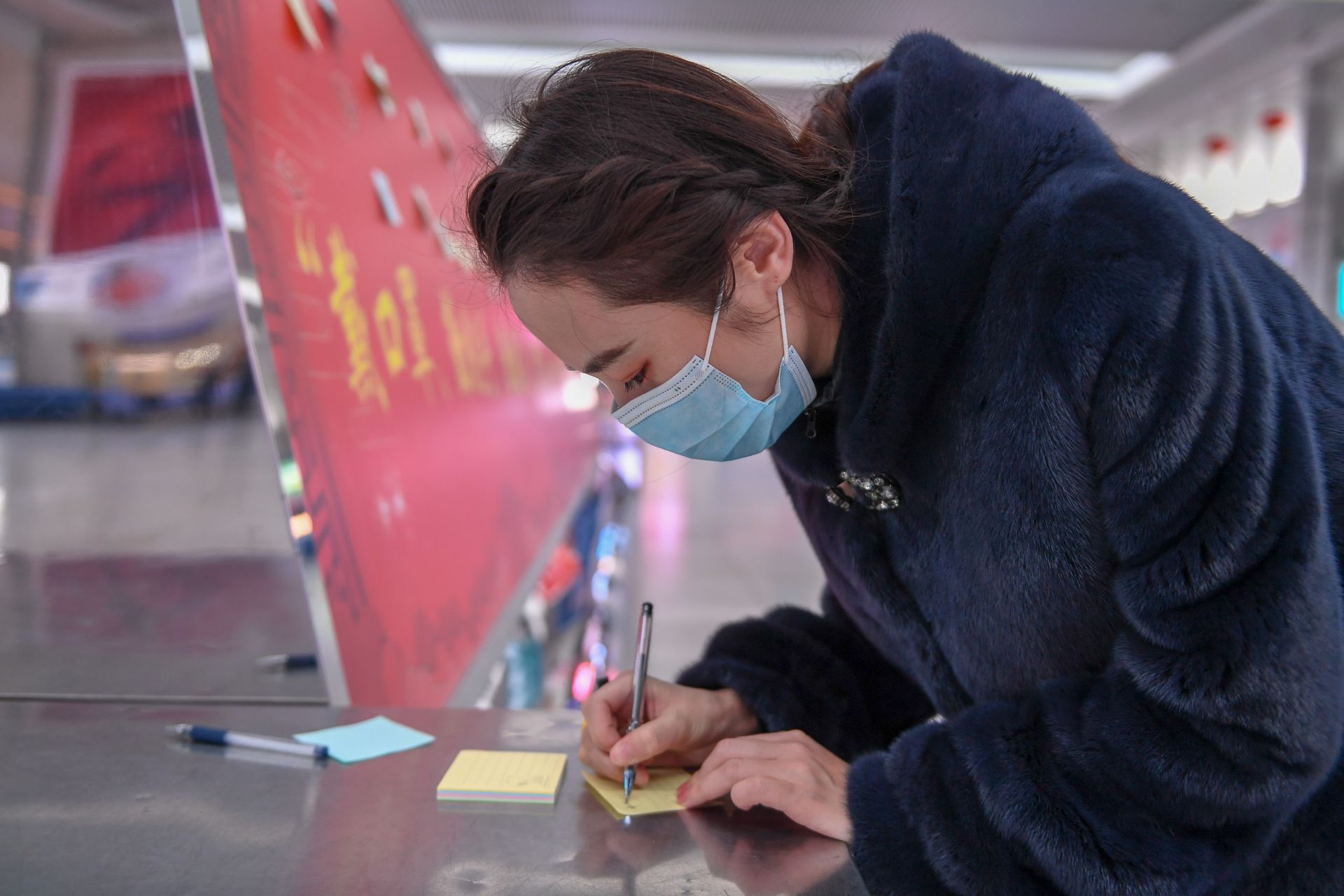 1月28日,一名旅客在长春站候车大厅写下新年寄语。(新华社) 1月28日,一名旅客在长春站候车大厅写下新年寄语。(新华社)