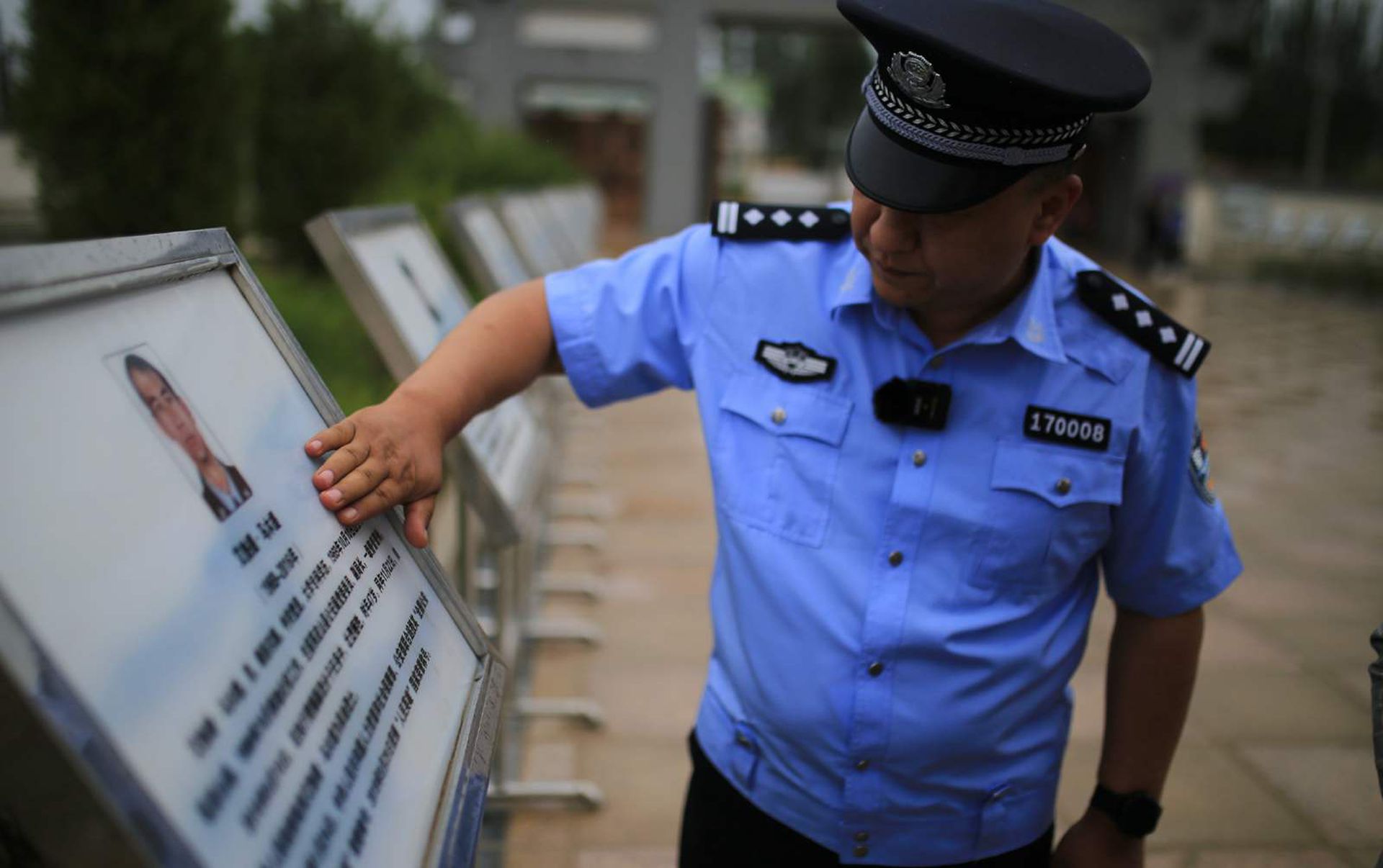 当地民警为牺牲的战友擦拭纪念牌。(微博@范凌志) 当地民警为牺牲的战友擦拭纪念牌。(微博@范凌志)