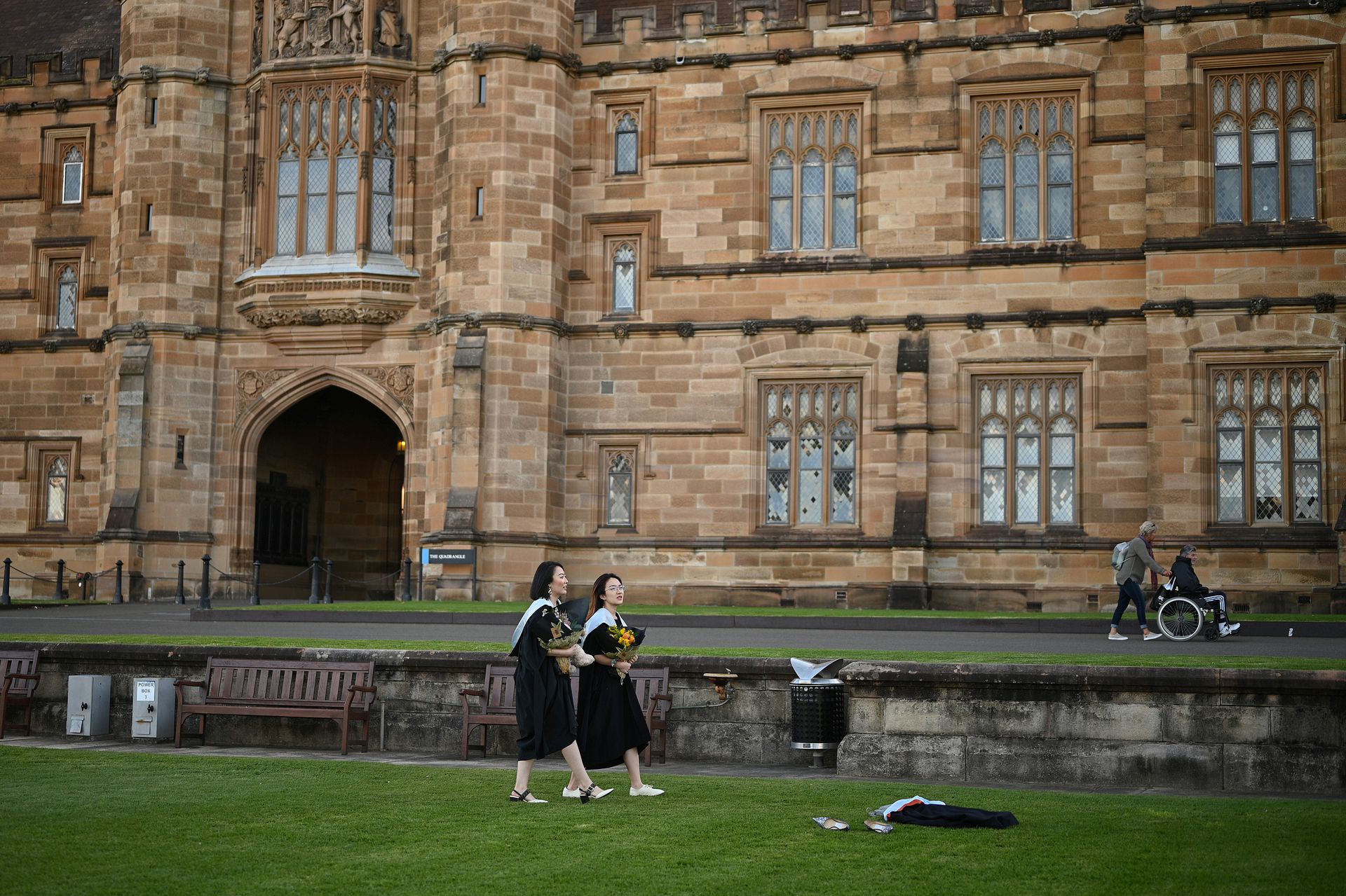 在面对面毕业典礼因新冠肺炎（COVID-19）疫情取消后，Shiyu Bao和同样来自中国的同学Katerina Ma穿着学位服在悉尼大学校园里拍照。（人民视觉）