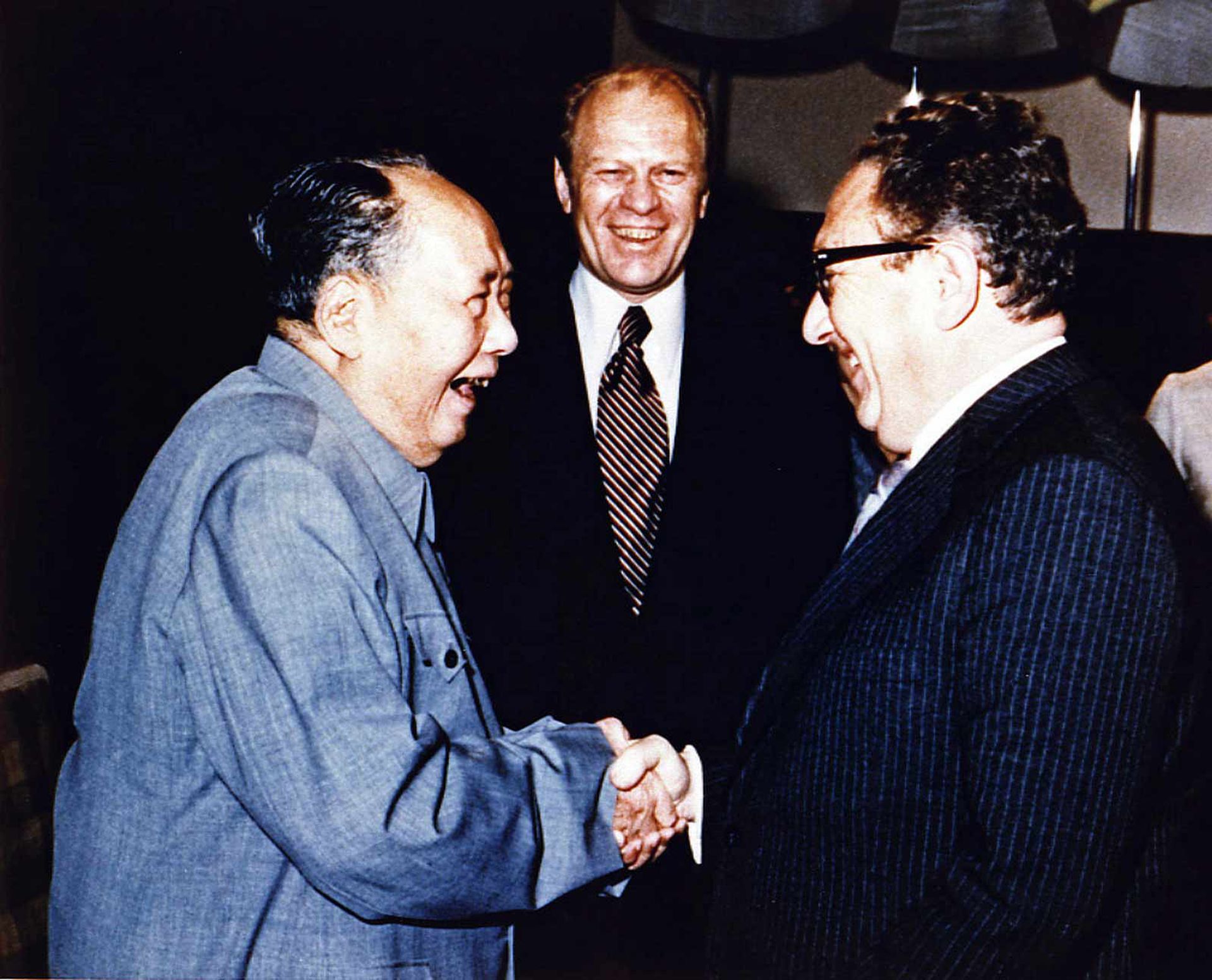 1975年12月，时任美国总统福特（Gerald Rudolph Ford）访华，毛泽东笑着与基辛格握手。（视觉中国）