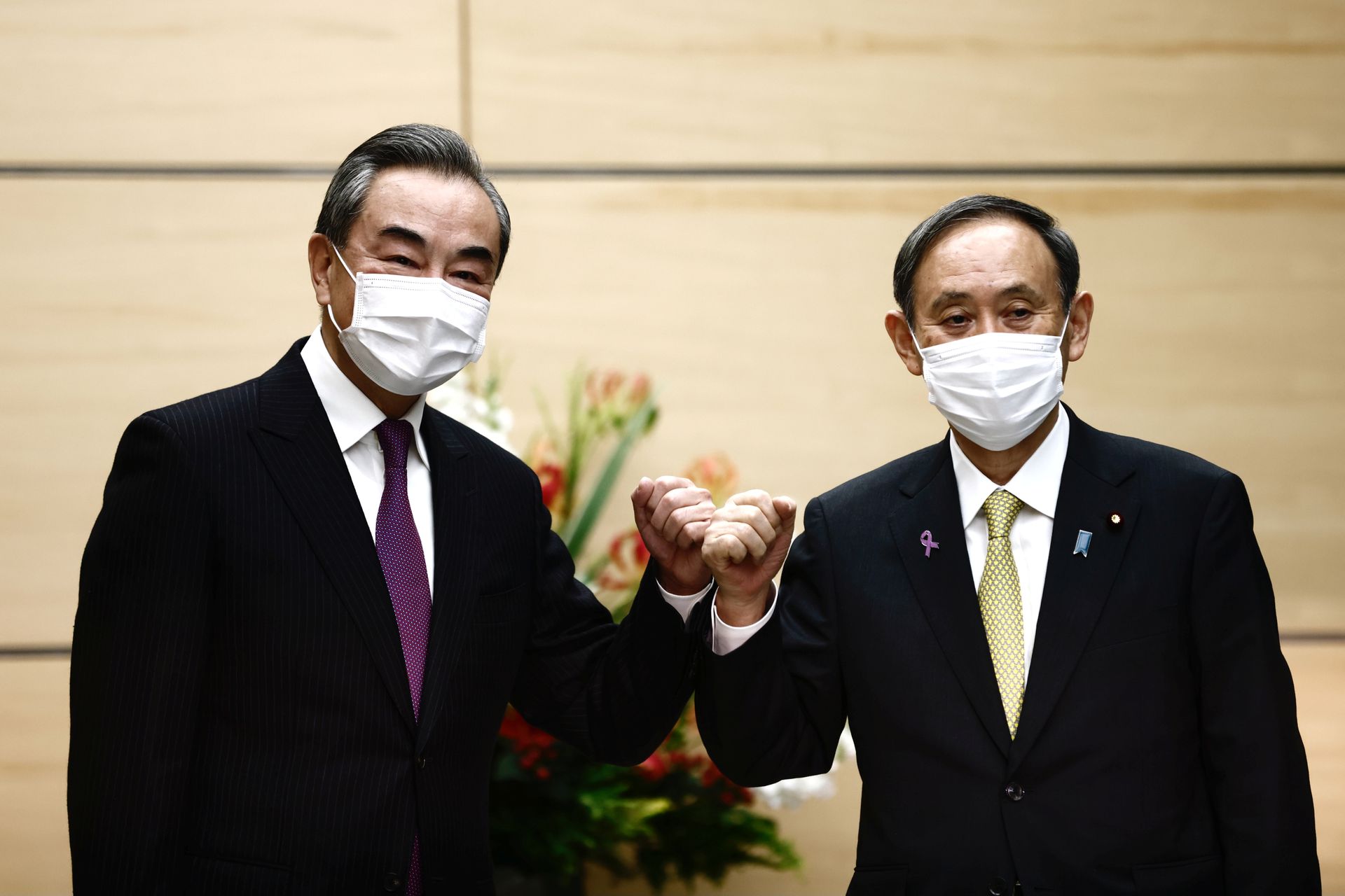 由于新冠肺炎（COVID-19）疫情，两人都戴着口罩。（Reuters）