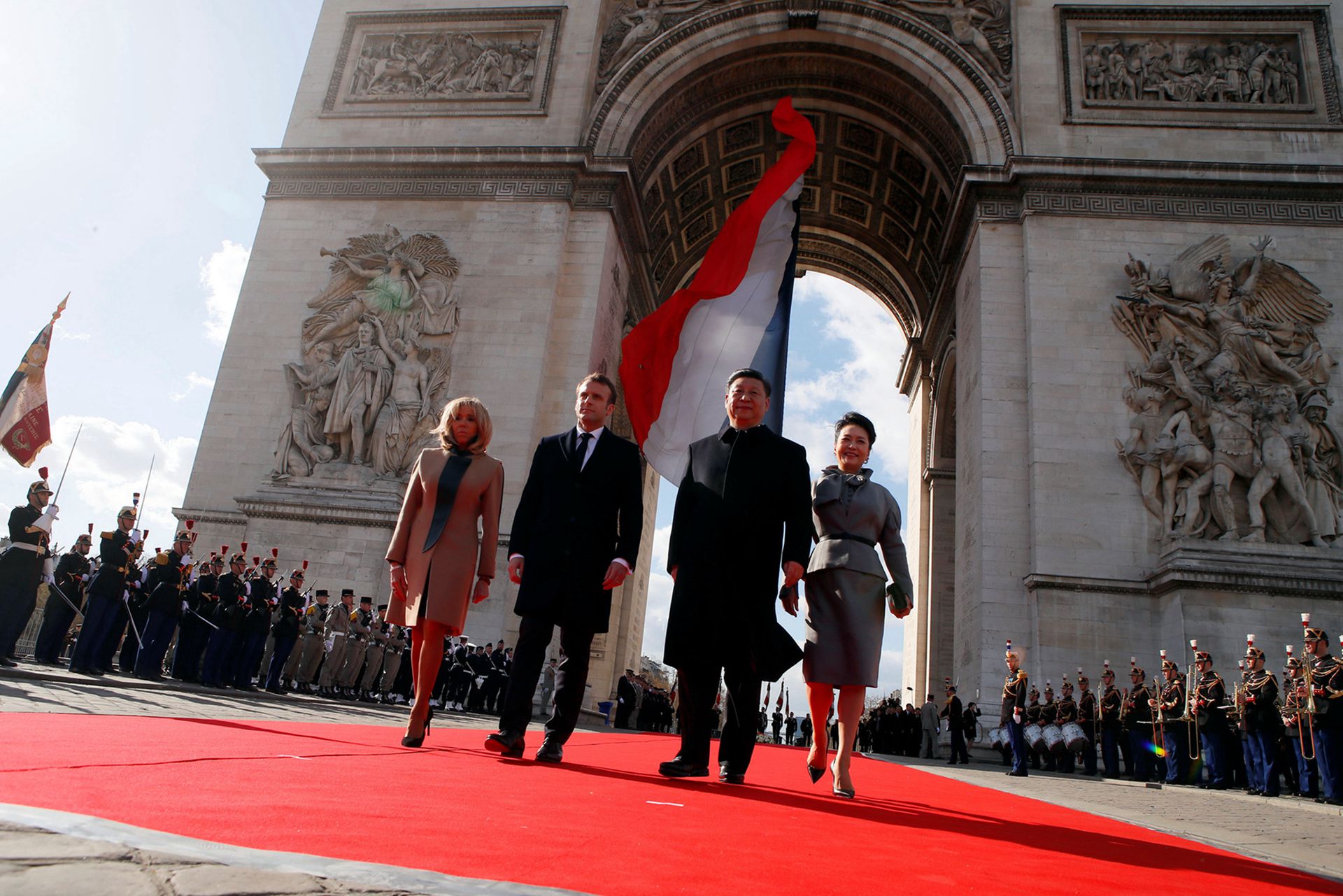 2019年3月25日，法国总统马克龙夫妇、中国国家主席习近平和夫人彭丽媛出席无名战士墓敬花圈仪式后离开凯旋门。（Reuters）