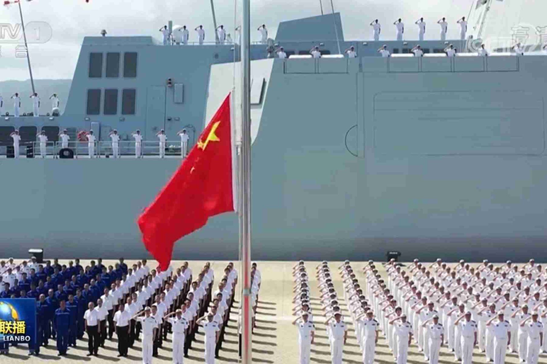 中国央视新闻公开入列现场画面。图为来自中国海军部队和舰艇科研生产单位的代表在舰艇前列队敬礼。（中国央视截图）
