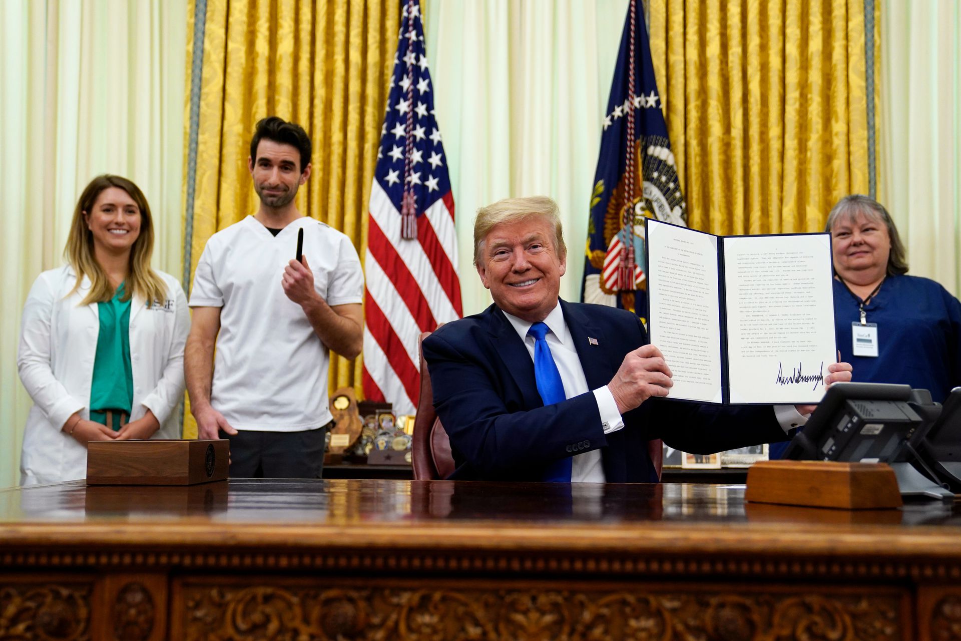 2020年5月6日，在华盛顿的白宫椭圆形办公室，美国总统特朗普展示签署的世界护士节宣言文件。（AP）
