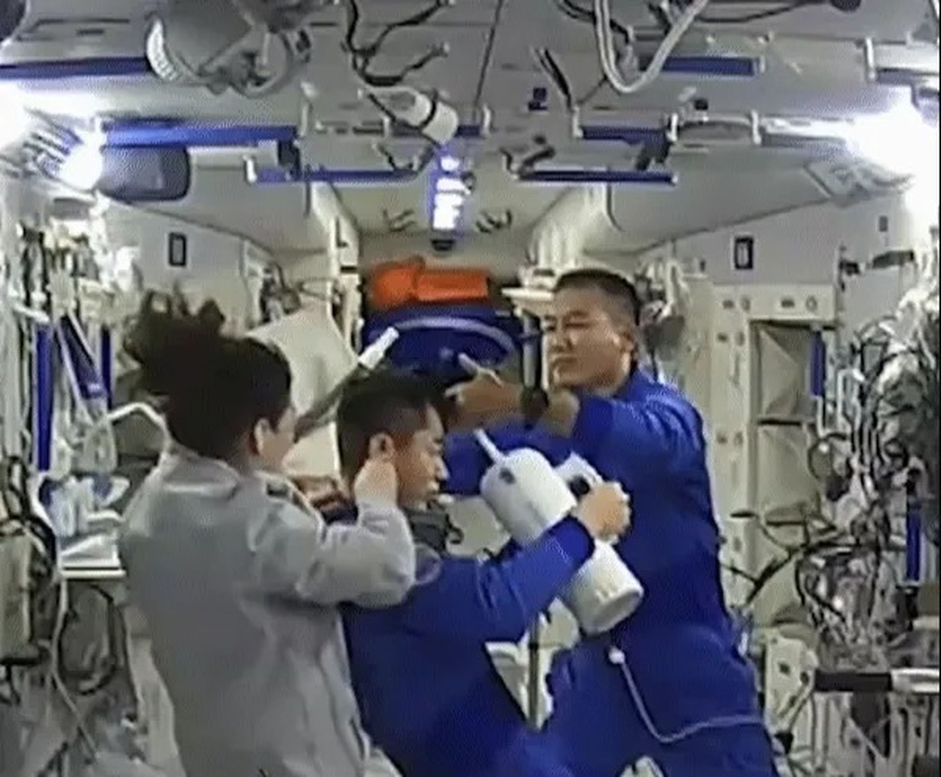 王亚平与翟志刚联合为叶光富理发,茶瓶形状的吸尘器惹人关注。(中国央视截图) 王亚平与翟志刚联合为叶光富理发,茶瓶形状的吸尘器惹人关注。(中国央视截图)