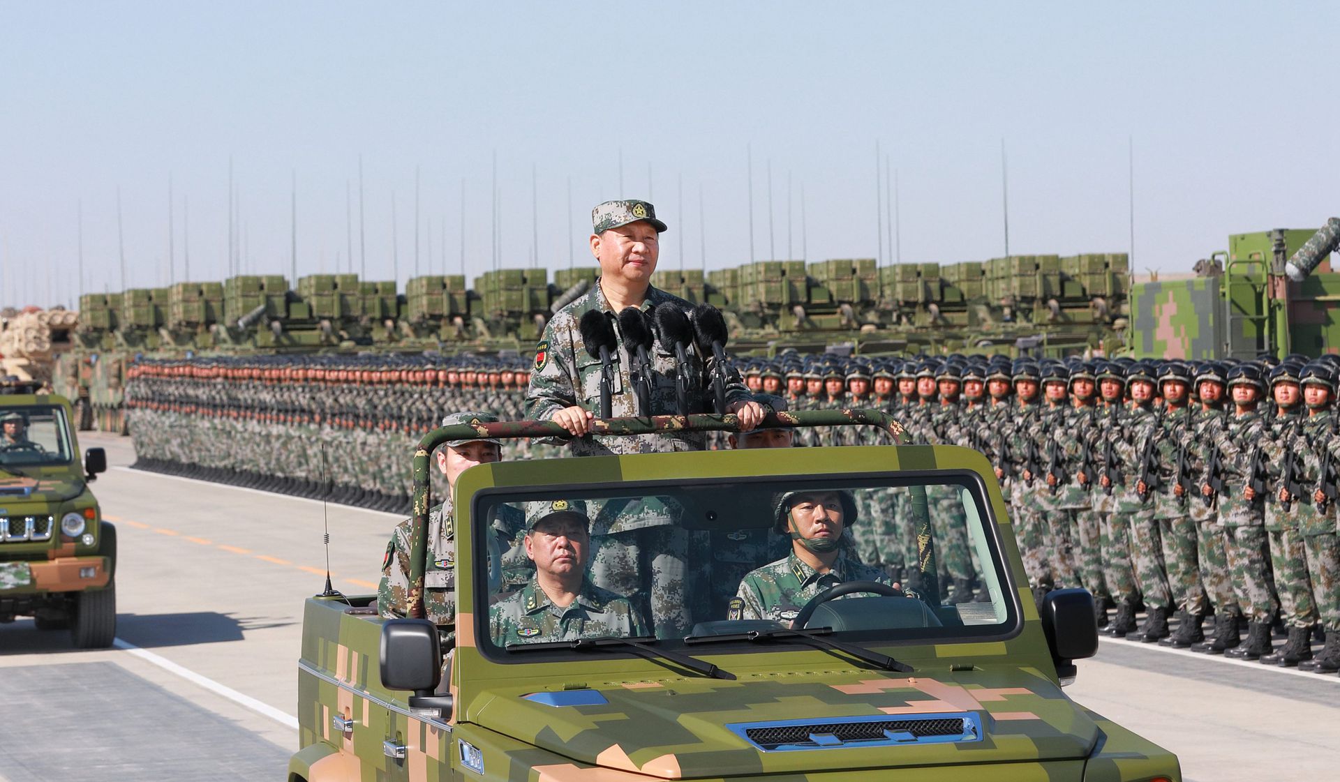 在内蒙古的朱日和训练基地，中国国家主席习近平身穿绿色迷彩服，登上越野车，检阅部队。（新华社）