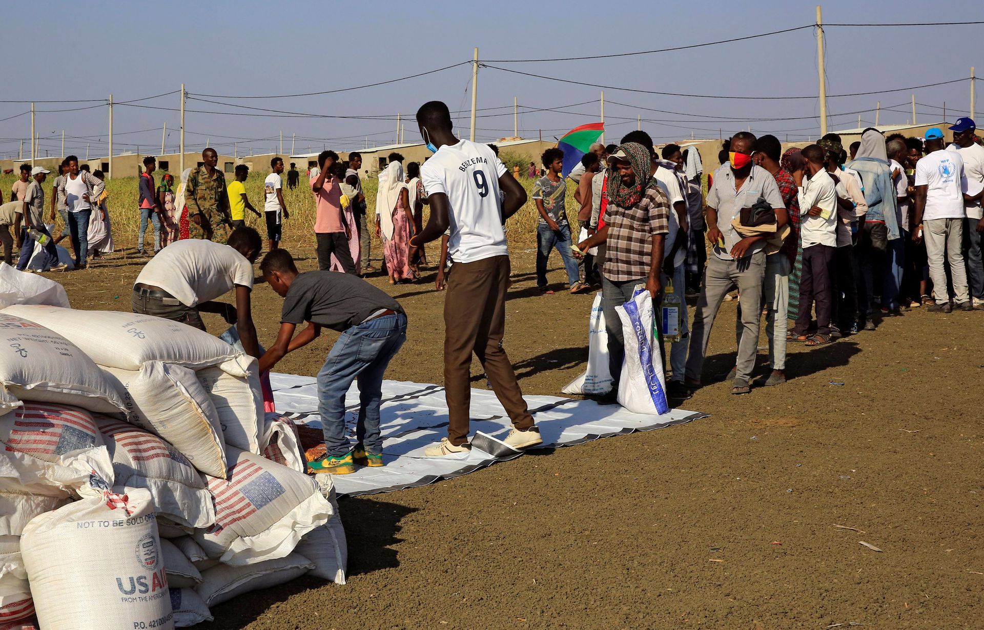 2020年11月20日，苏丹Al-Qadarif州，逃离提格雷地区战争的埃塞俄比亚人在苏丹-埃塞俄比亚边境的Fashaga难民营排队领取世界粮食计划署的救援物资。(Reuters)