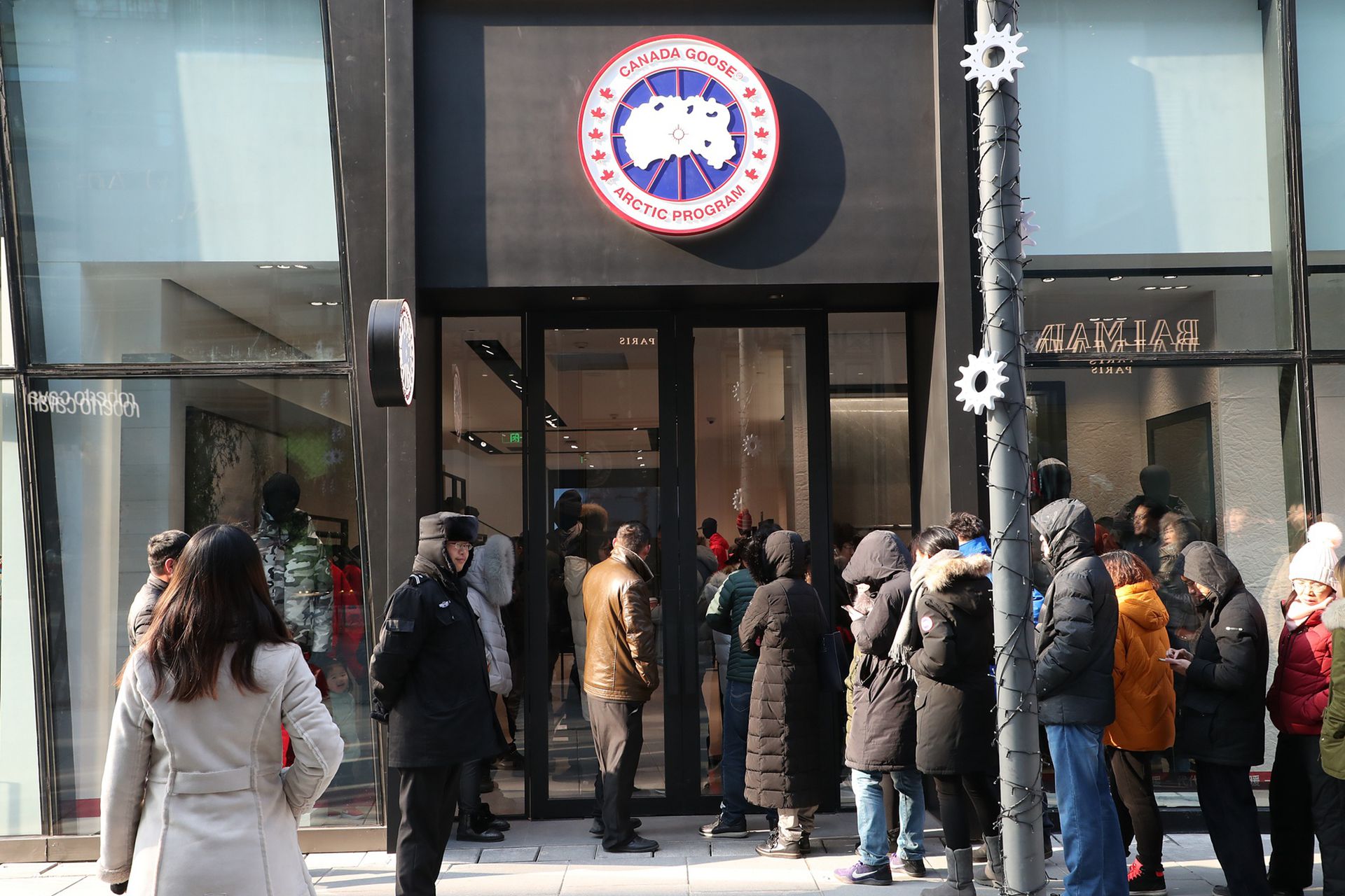 加拿大高端羽绒服品牌北京三里屯旗舰店正式开业时，诸多消费者排队等候。（视觉中国）