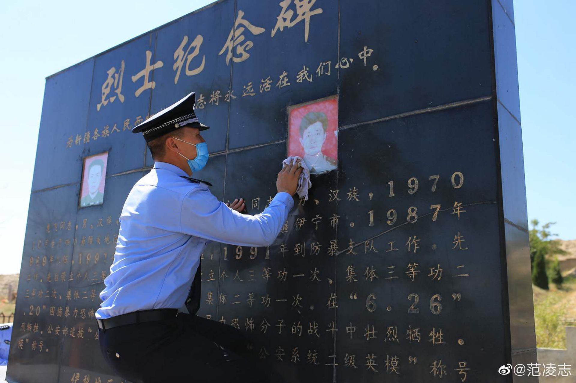当地民警为牺牲的战友擦拭墓碑。(微博@范凌志) 当地民警为牺牲的战友擦拭墓碑。(微博@范凌志)