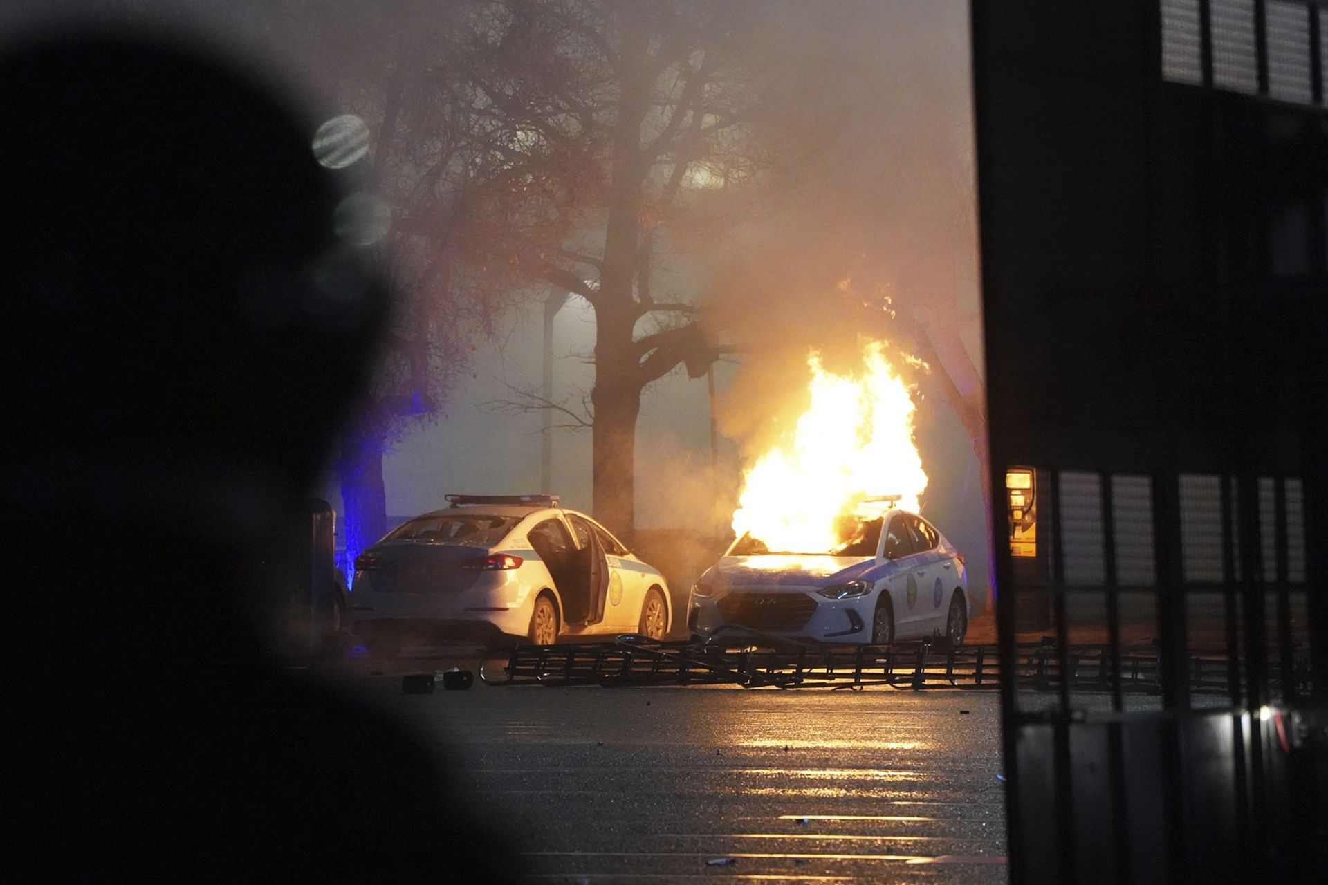 抗议民众点燃停在路边的警车。（AP）