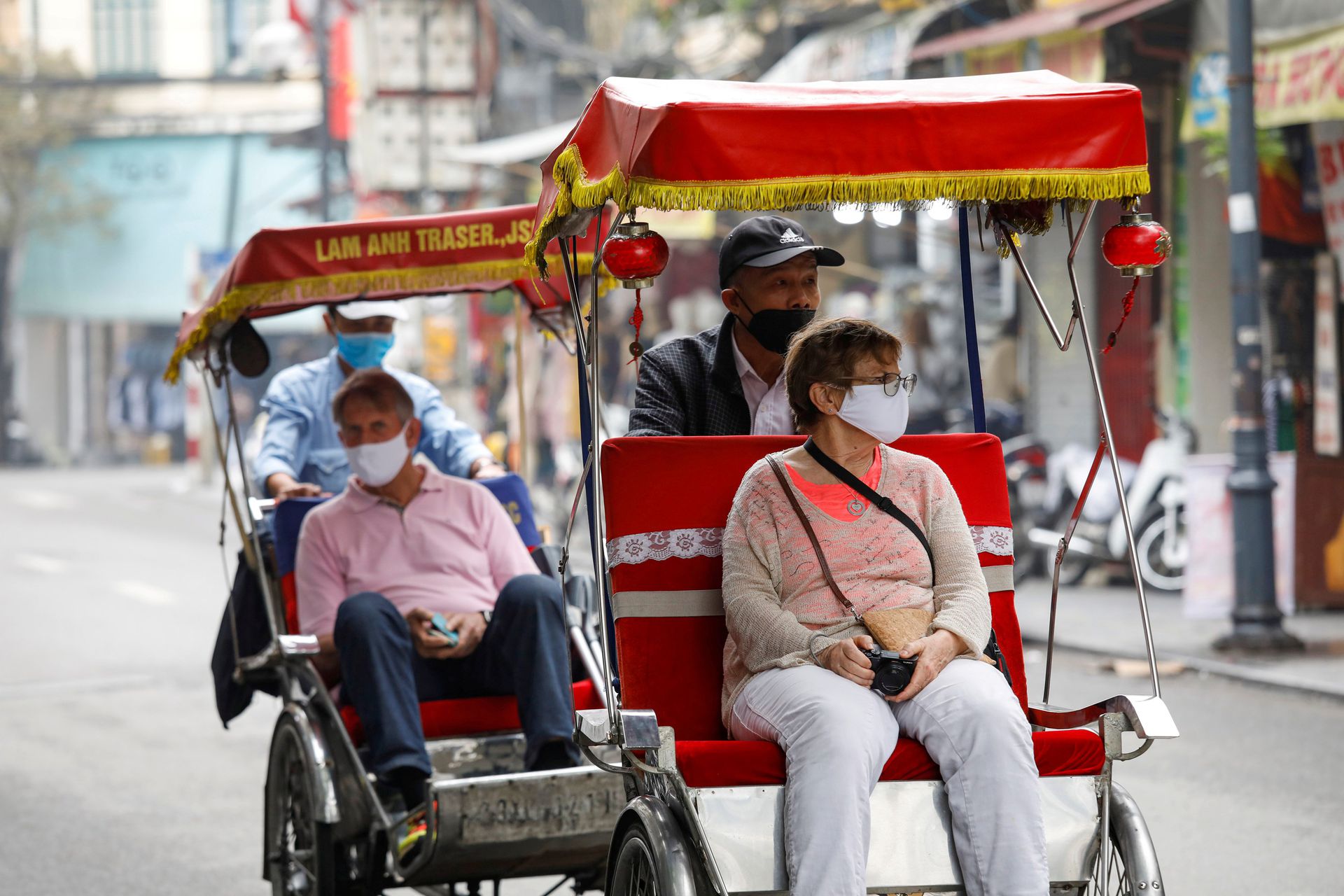 两名外国游客在2020年3月时戴着口罩，搭乘载客三轮车徜徉于越南河内老城区的街道。此后，越南开始了更为严格的封闭与防疫措施，到2020年6月，越南全境只接纳了约九千名外国旅游者。此举虽然让越南的旅游业陷入冰点，但对国内防疫态势形成了有效的帮助。（路透社）