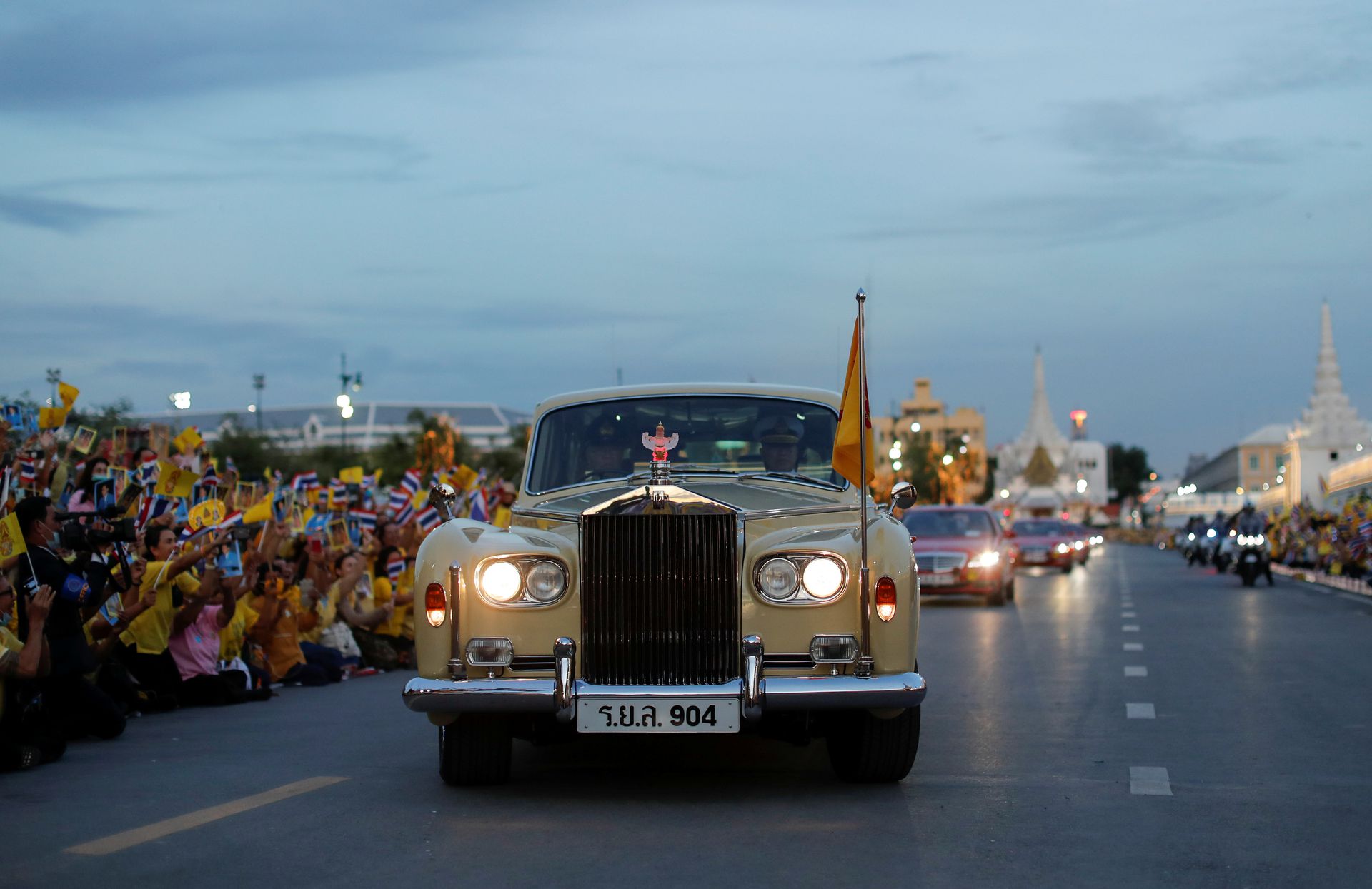 泰国民众在道路两旁欢迎国王哇集拉隆功车队。（Reuters）