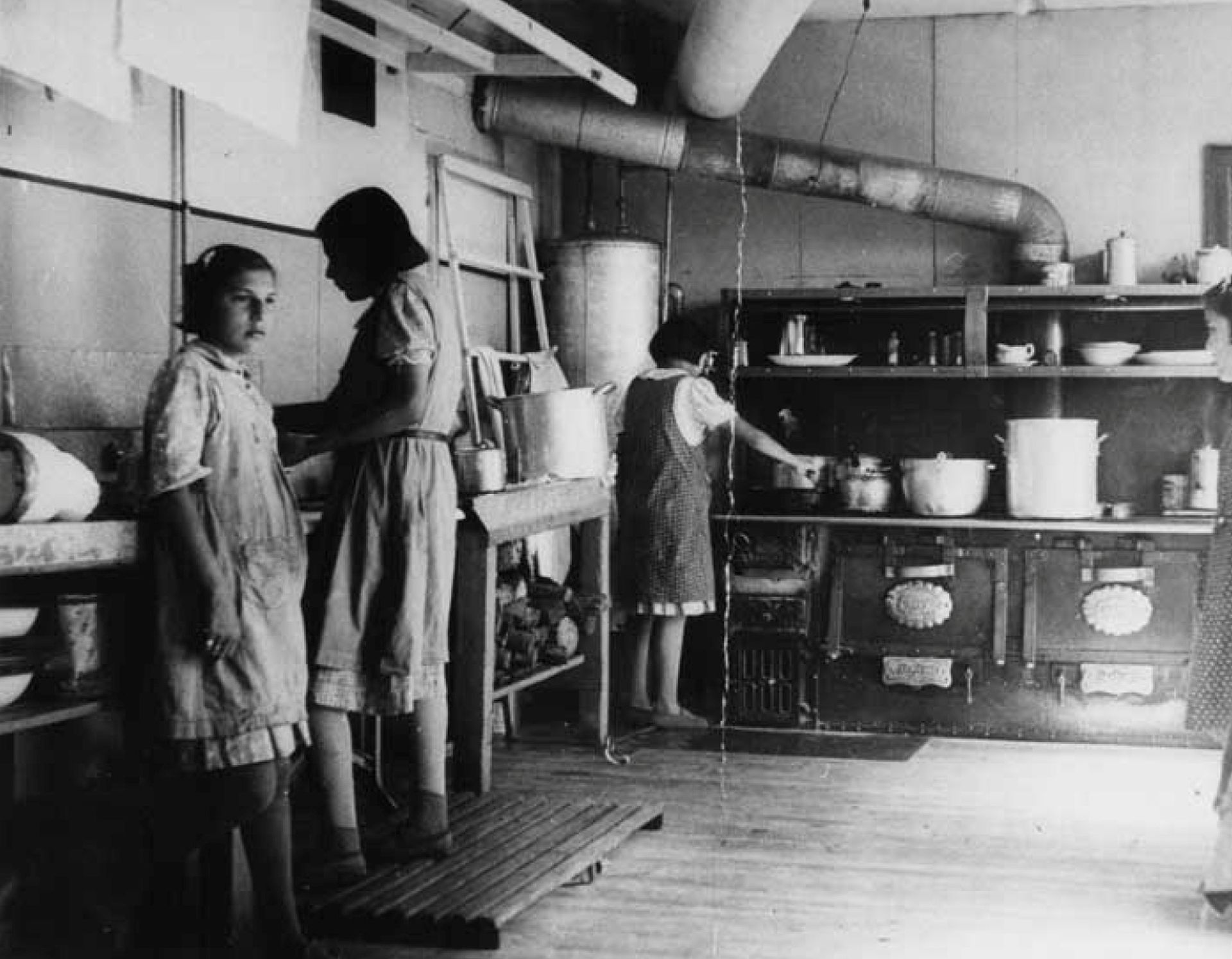 1940年左右，在加拿大安大略省寄宿学校Bishop Horden Memorial School的厨房里，人们正在工作。（Reuters）