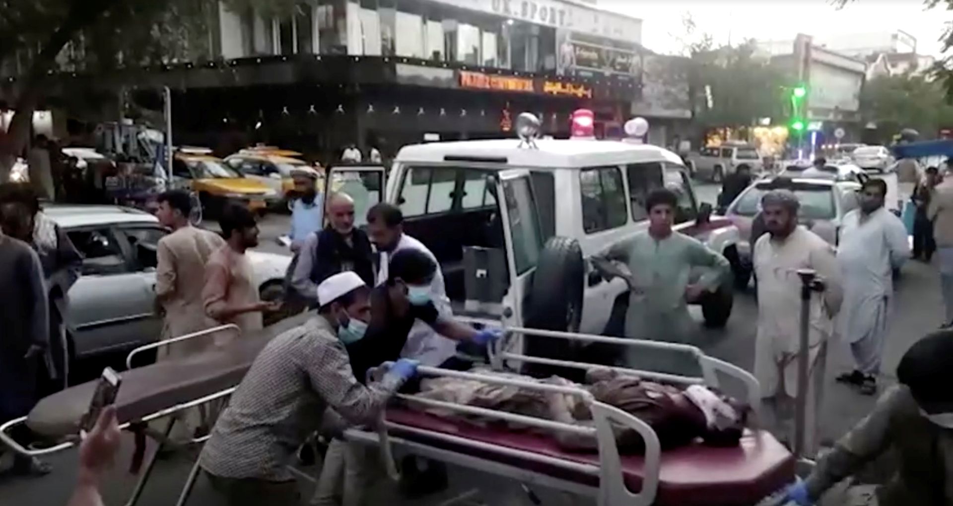 2021 年 8 月 26 日在阿富汗喀布尔的喀布尔机场遭到袭击后，人们将一名受伤人员送往医院。（Reuters）