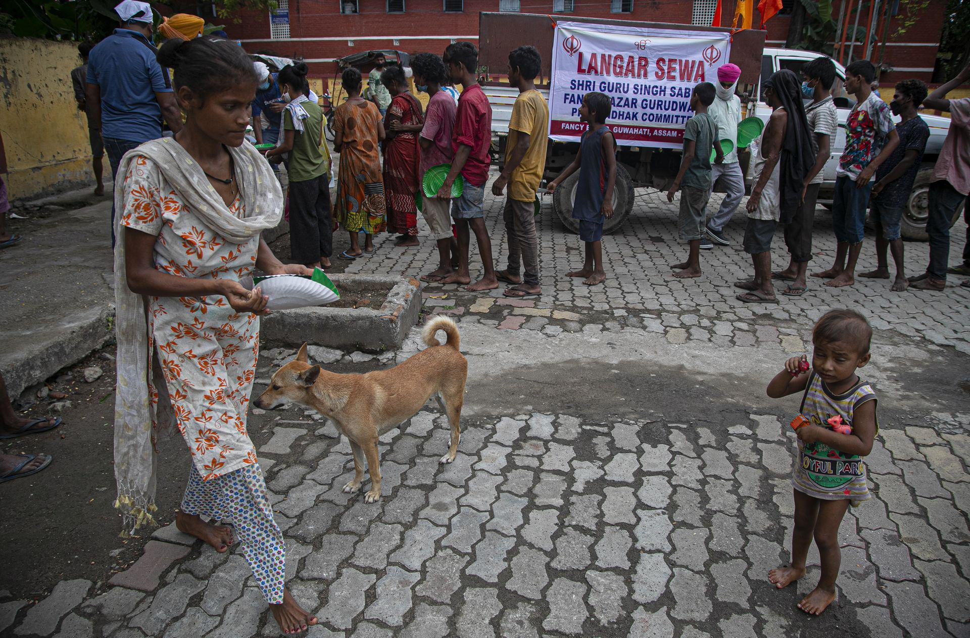 2020年9月6日，印度无家可归的人排队等候获得锡克教徒在印度高哈蒂市分发的免费食物。印度的冠状病毒病例已超过400万人，在新感染方面居世界领先地位，并在该国广阔腹地加深了苦难激增削弱了资金不足的医疗体系。（AP）