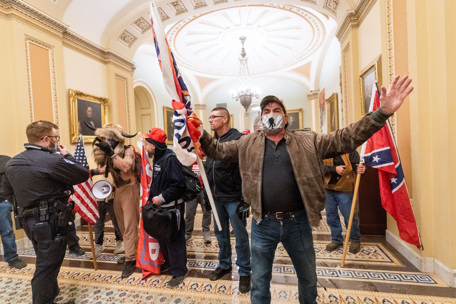 2021年1月6日，特朗普的支持者在华盛顿国会大厦内的参议院大厅外，与国会警察对峙。（AP）