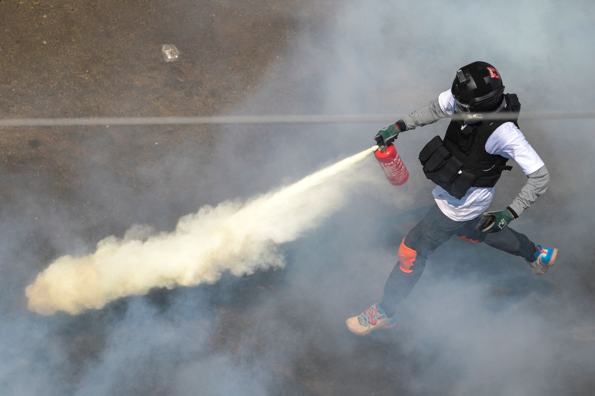 相比之下，示威者虽然装备简陋，仍然可以使用干粉灭火器制造烟雾。（路透社）