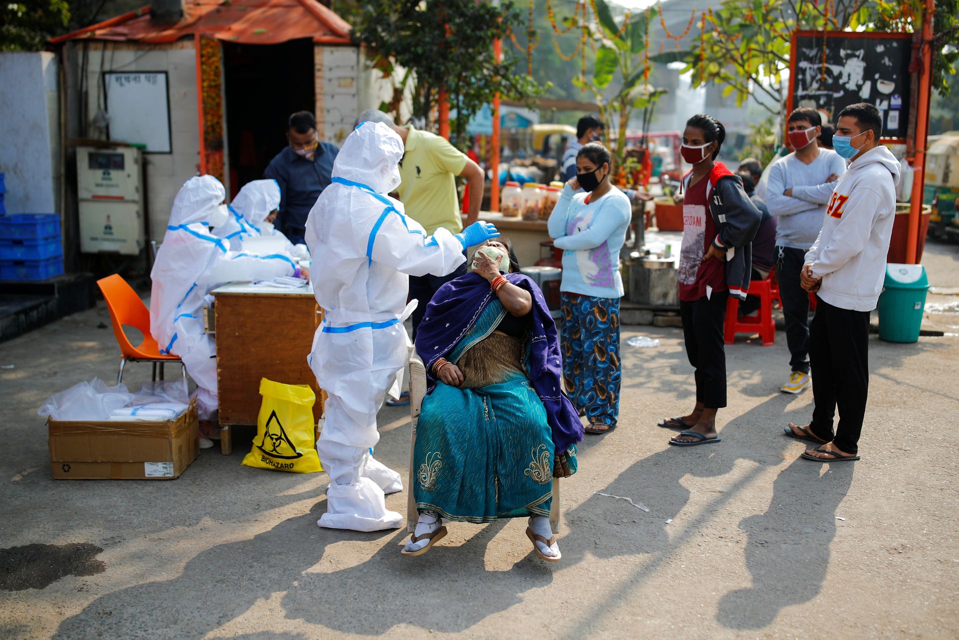 在印度德里与北方邦边界的地区，医护人员在当地路边设卡为民众检测新冠。此地随后也成了北方邦农民前往新德里并与军警斗智斗勇的舞台。（路透社）