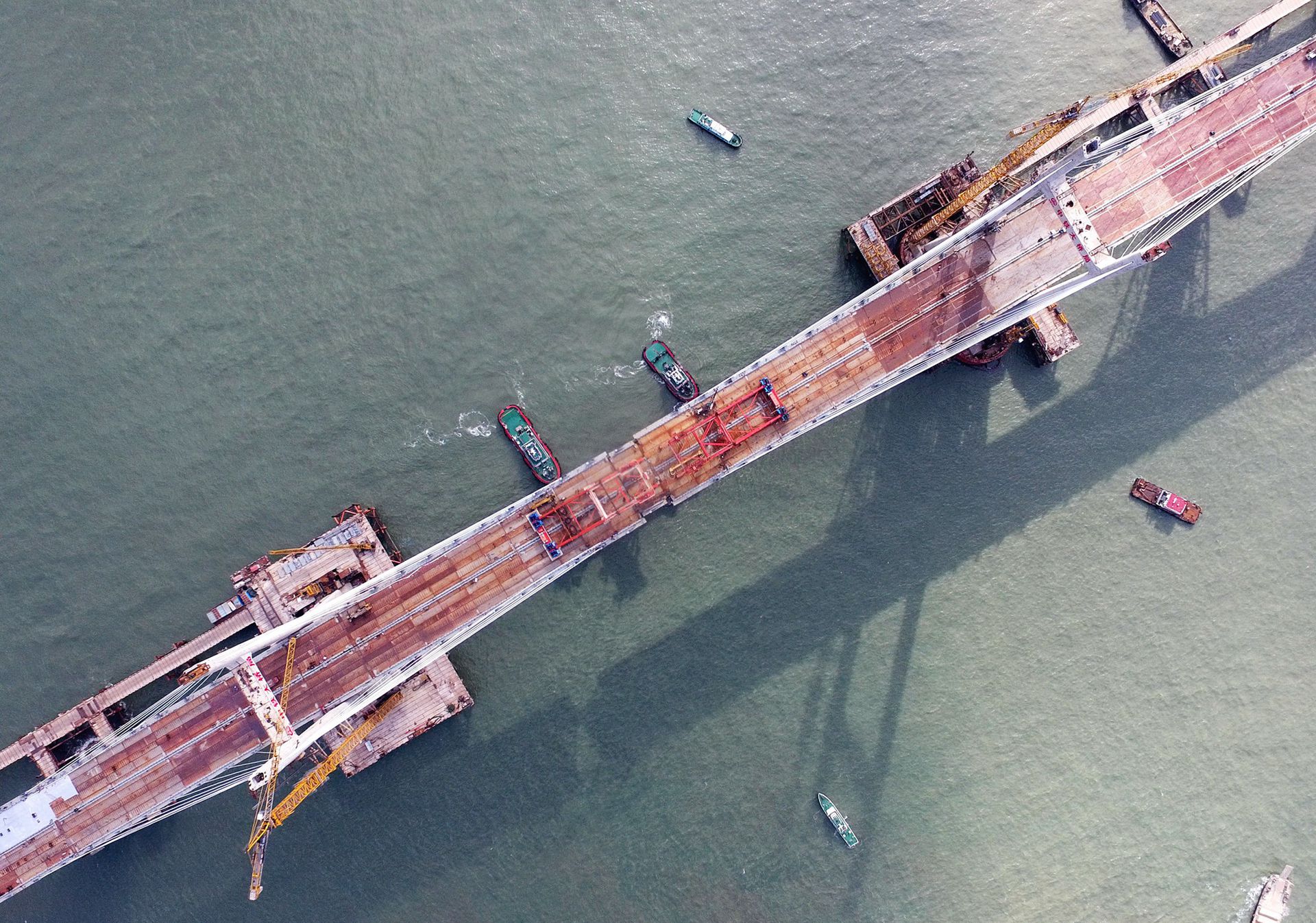 2019年9月25日上午，随着一段长17米、重473吨的钢桁梁被精确固定到位，总长16.34公里的平潭海峡公铁大桥合龙贯通。（新华社）