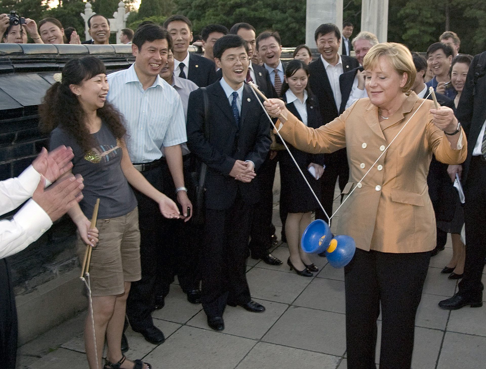 2007年8月27日，德国总理默克尔参观北京中山公园，学习抖空竹。（视觉中国）