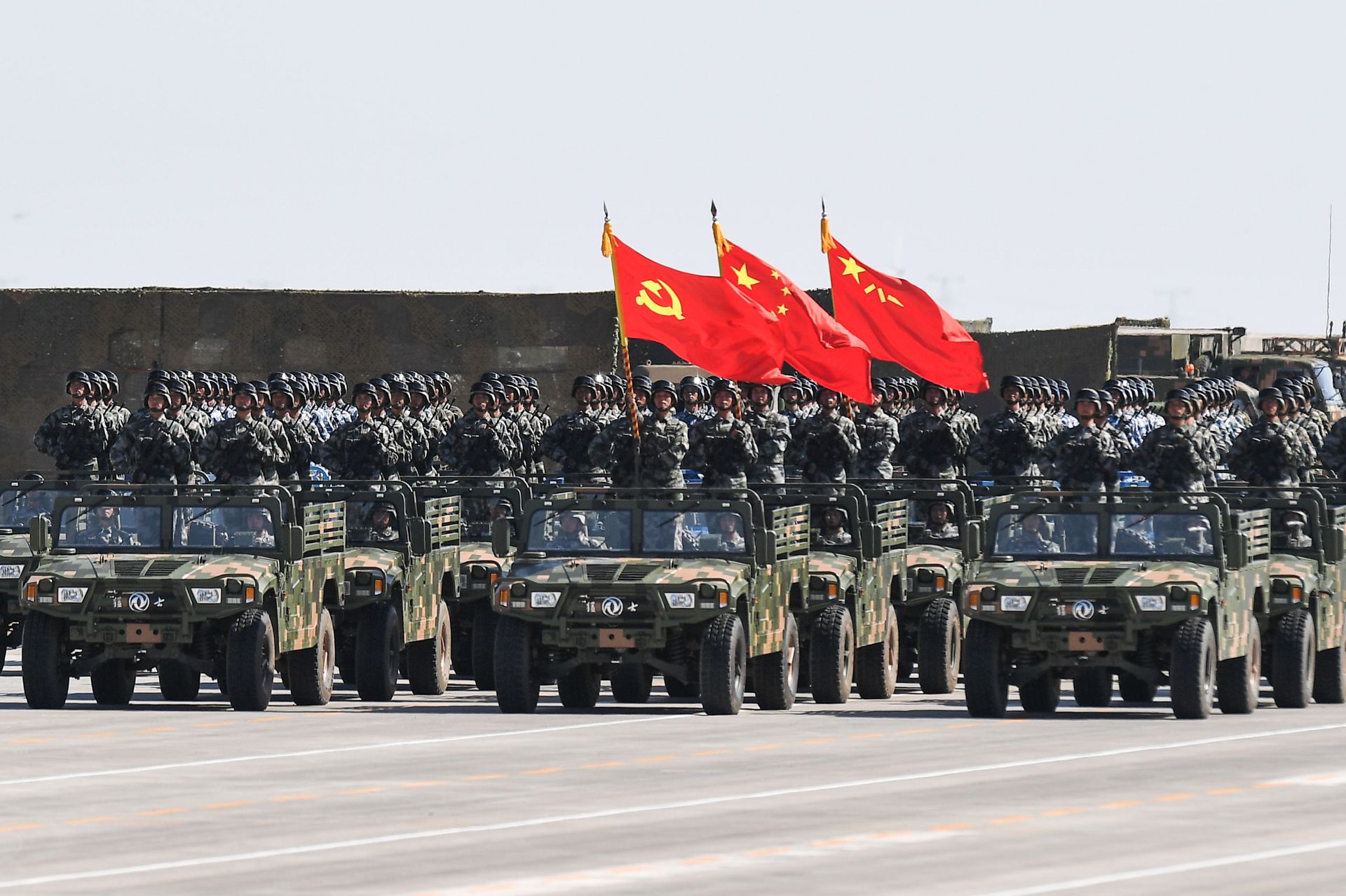 阅兵现场，解放军护旗方队举起中国共产党党旗、中华人民共和国国旗、中国人民解放军军旗接受检阅。（新华社）