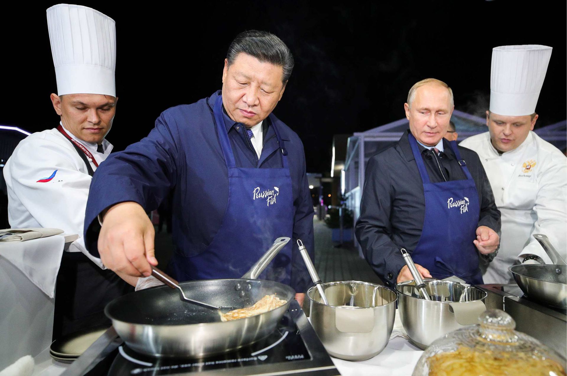 2018年9月11日，参观符拉迪沃斯托克美食街期间，普京指导习近平制作当地特色食品。（Reuters）