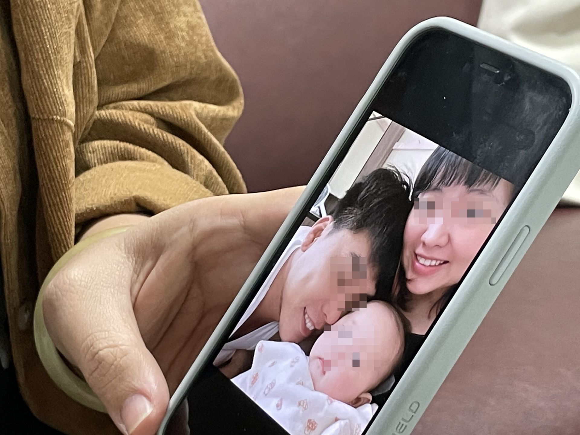猝死女婴母亲向台媒展示手机相簿中一家人的合影。（中央社）