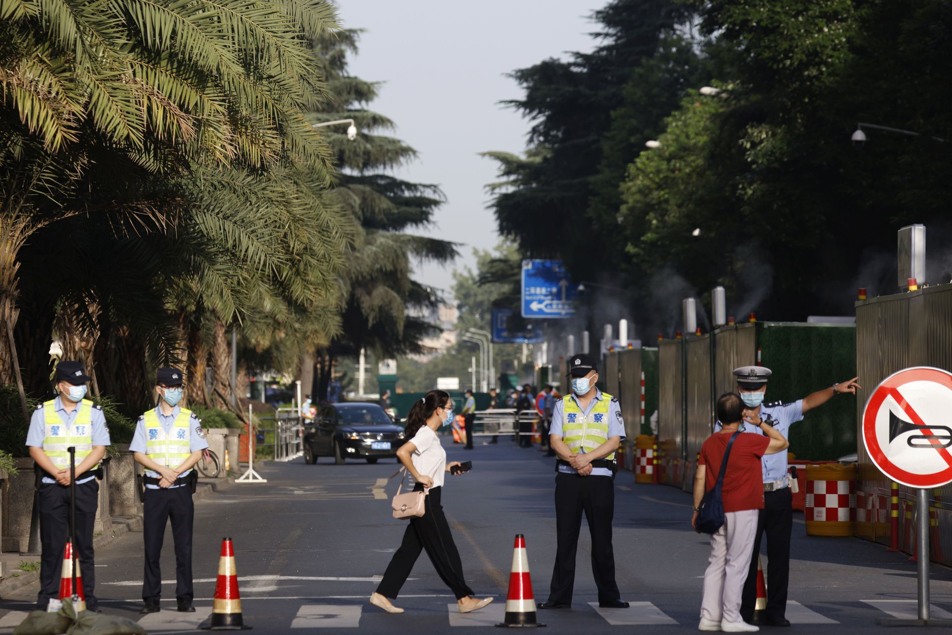 2020年7月27日，在美国驻成都总领事馆正式关闭之前，中国警察引导居民离开一个被封锁的社区。（AP）