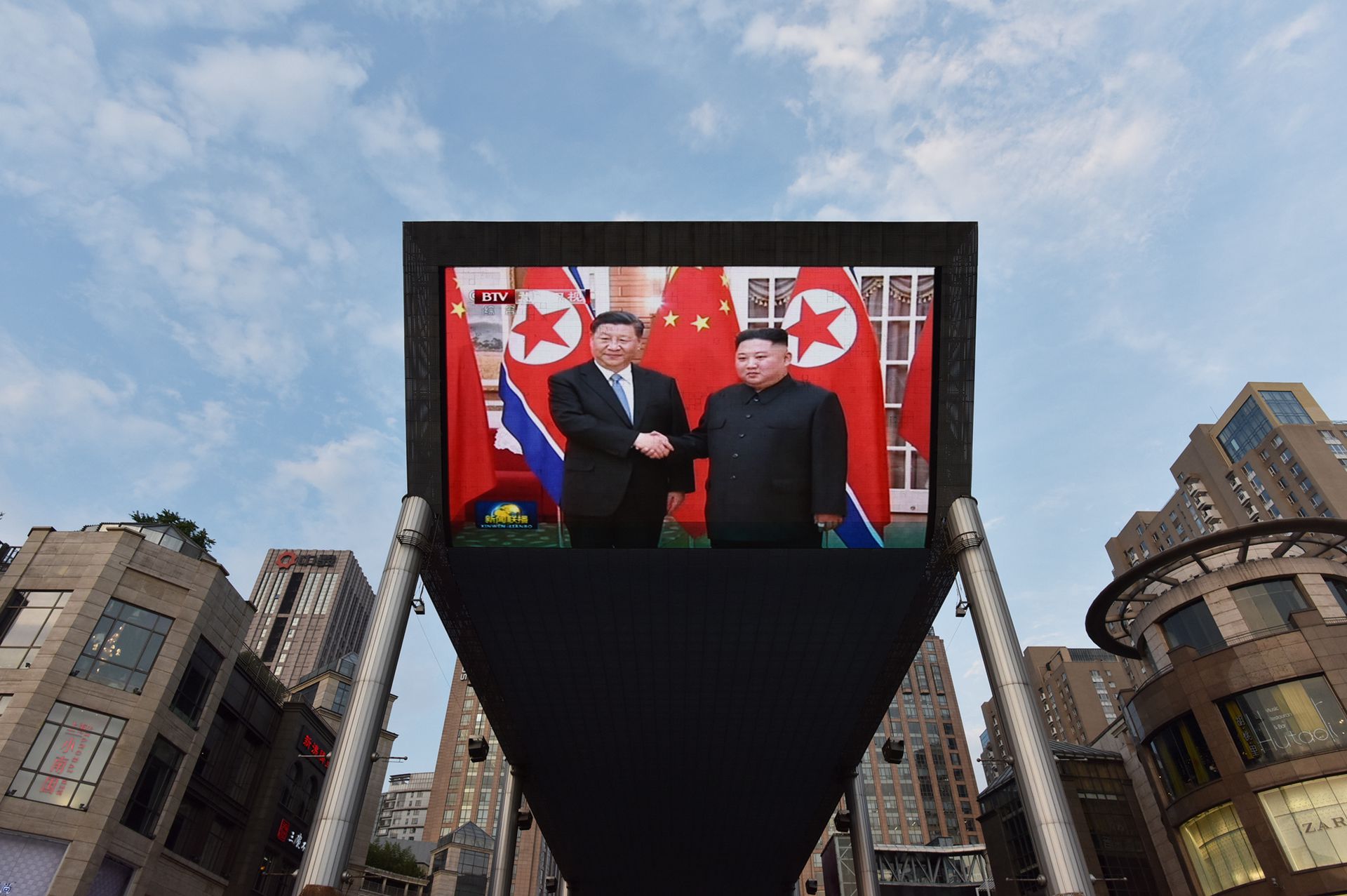 2019年6月20日，习近平在平壤受到金正恩欢迎的新闻画面出现在北京一家购物中心外的大屏幕上。（AFP）