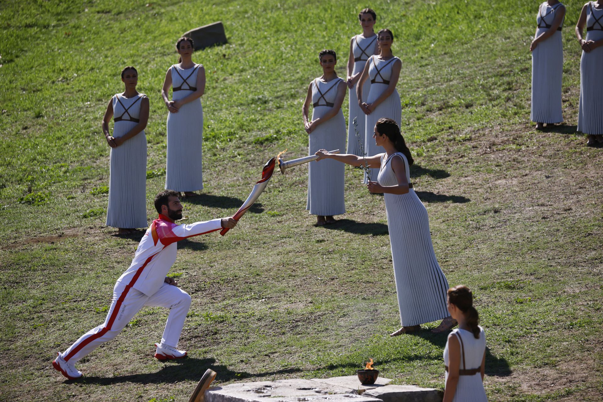 扮演女祭司的演员将圣火传递给第一个火炬手希腊滑雪运动员安东尼奥。（Reuters）