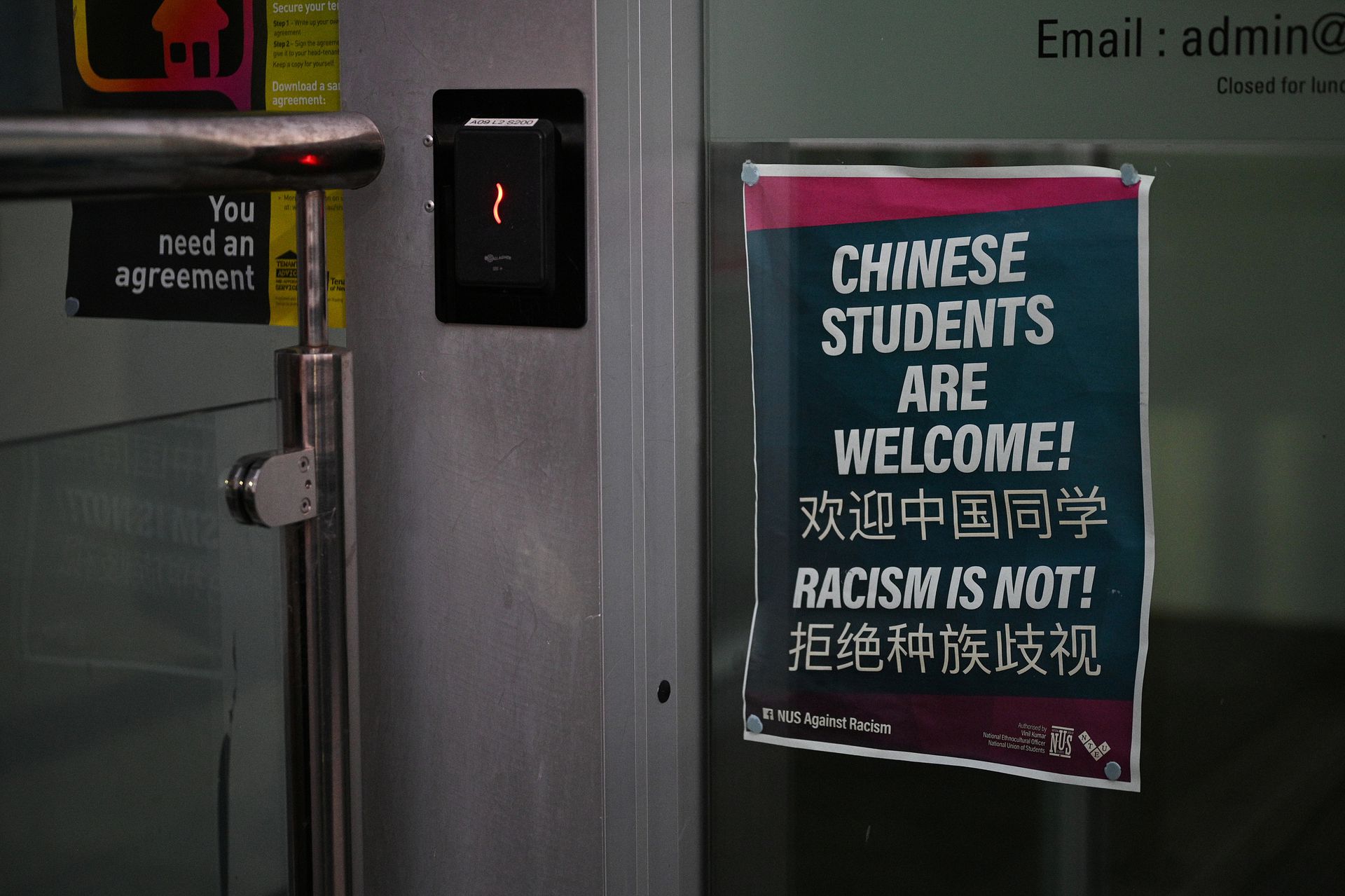 2020年8月11日，澳大利亚悉尼大学校园内悬挂着“欢迎中国同学，拒绝种族歧视”的海报。（人民视觉）