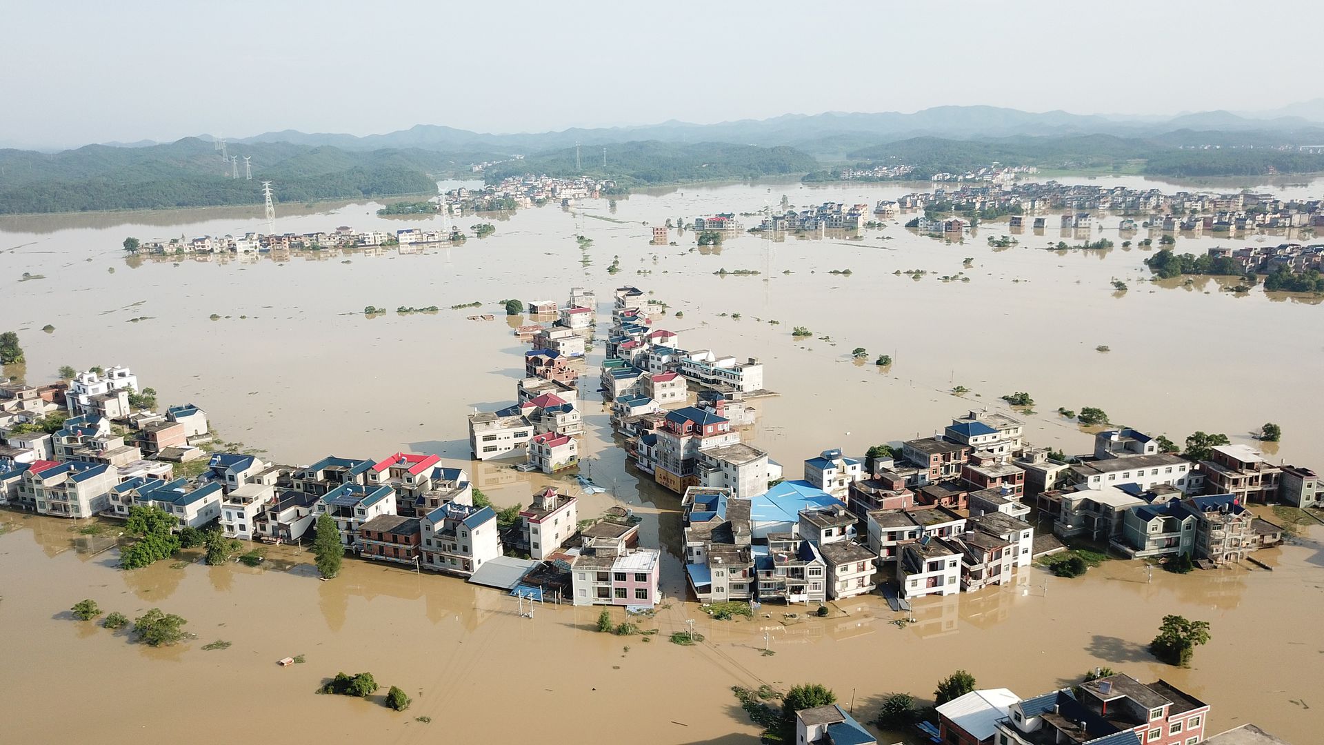 2020年中国南方洪灾，大量民房被淹，截至7月13日7时，共有141人死亡失踪。鄱阳湖流域正面临1998年以来最为严峻的防汛形势。 图为7月13日，江西上饶市的部分村民房屋和农田已被洪水淹没。（人民视觉）