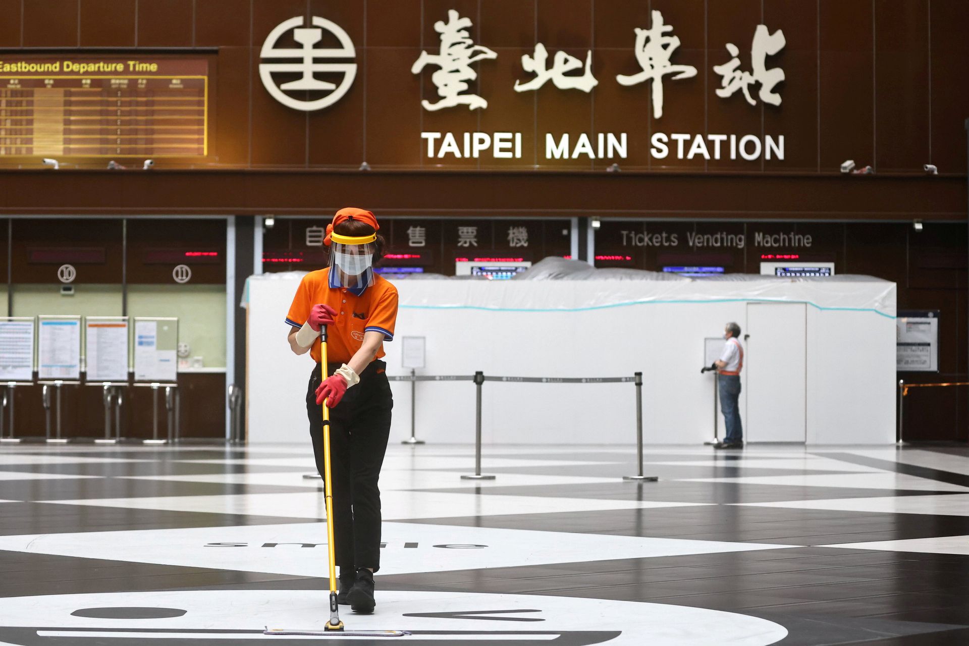 2021年5月18日，台湾台北市，一名妇女在清理台北市总站大厅时戴着口罩和面罩。（路透社）