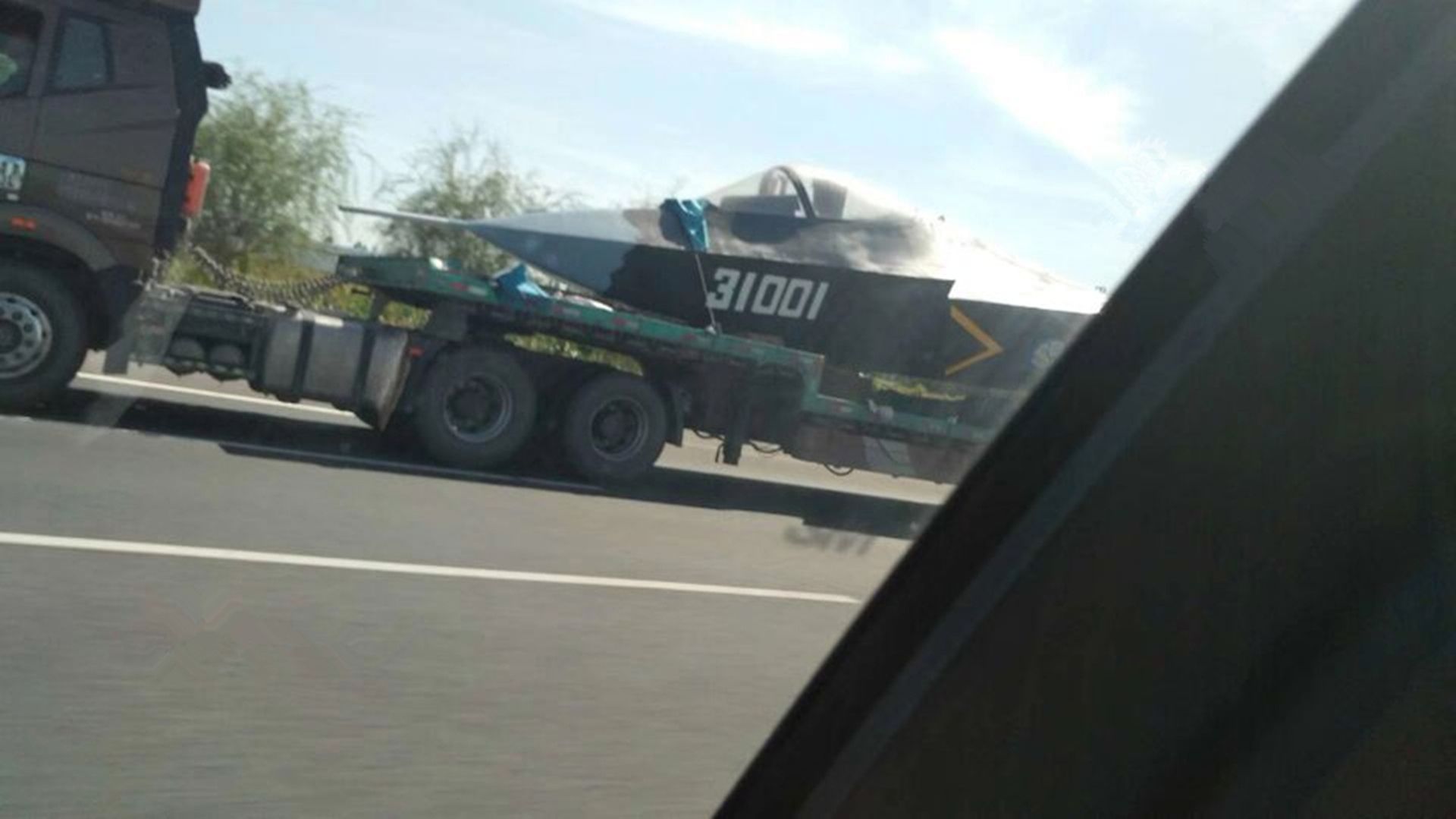 2018年9月，中国大陆军事网友在公路上偶然拍到一辆重型卡车，卡车上搭载着疑似歼-31首架验证机的模型。（微博@梁无咎）