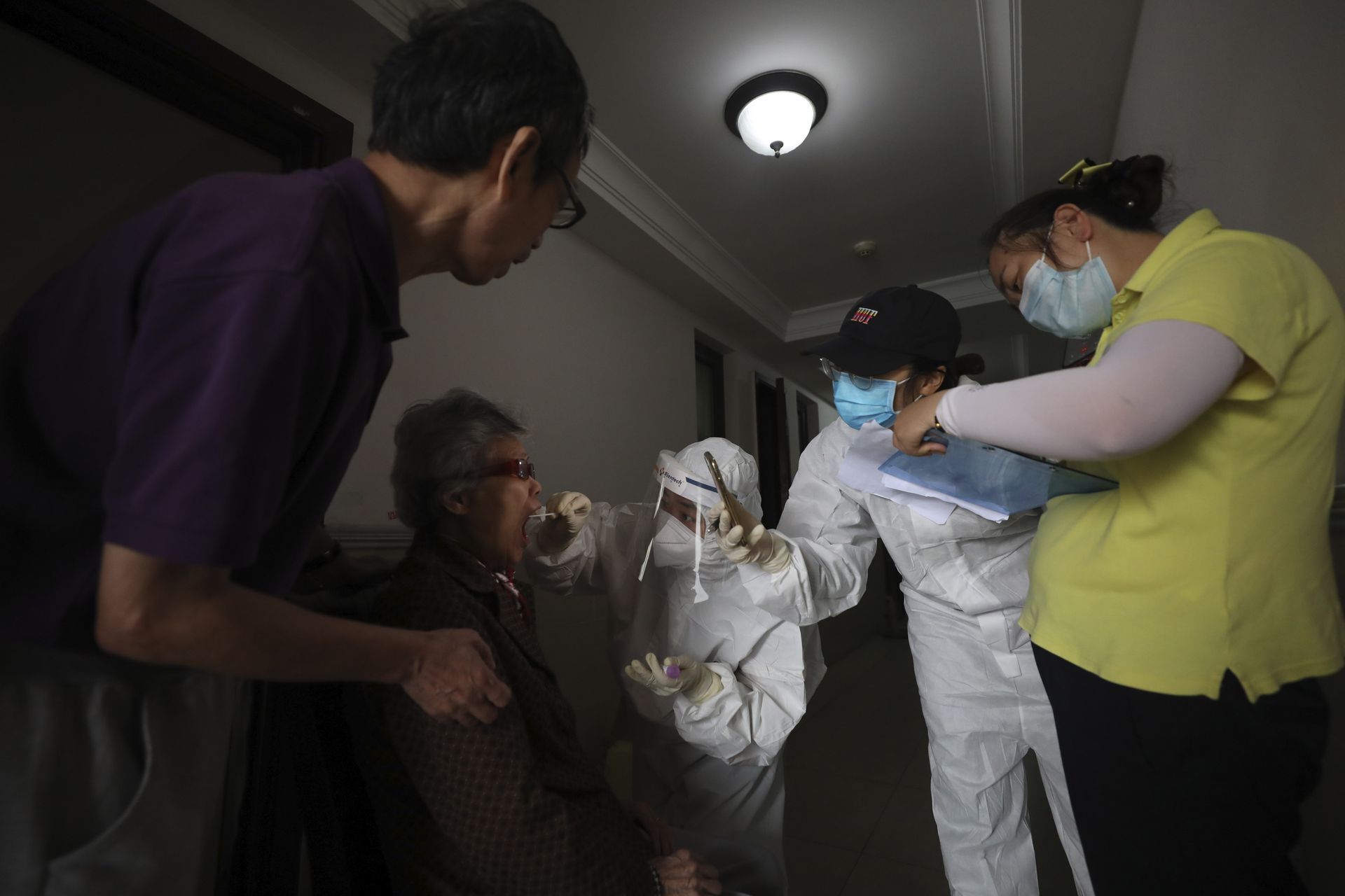 2020年5月14日武汉,一名医护人员从一名居民身上采集样本,进行冠状病毒检测。武汉社区已经开始对居民进行新型冠状病毒检测,具体实施10天内对1,100万人口的武汉市所有人进行检测的项目。 (AP)