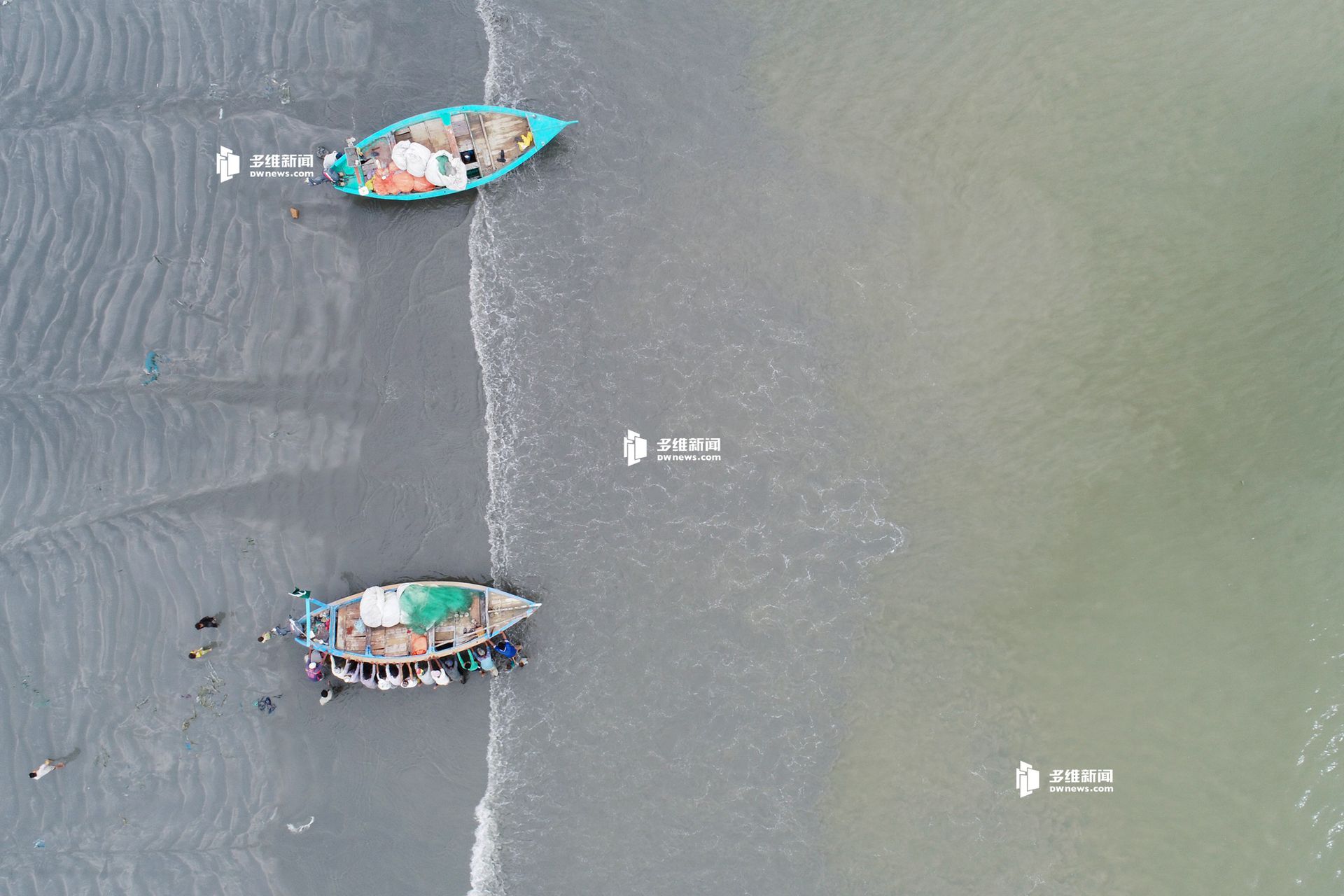 巴基斯坦渔民正在把船推下水。