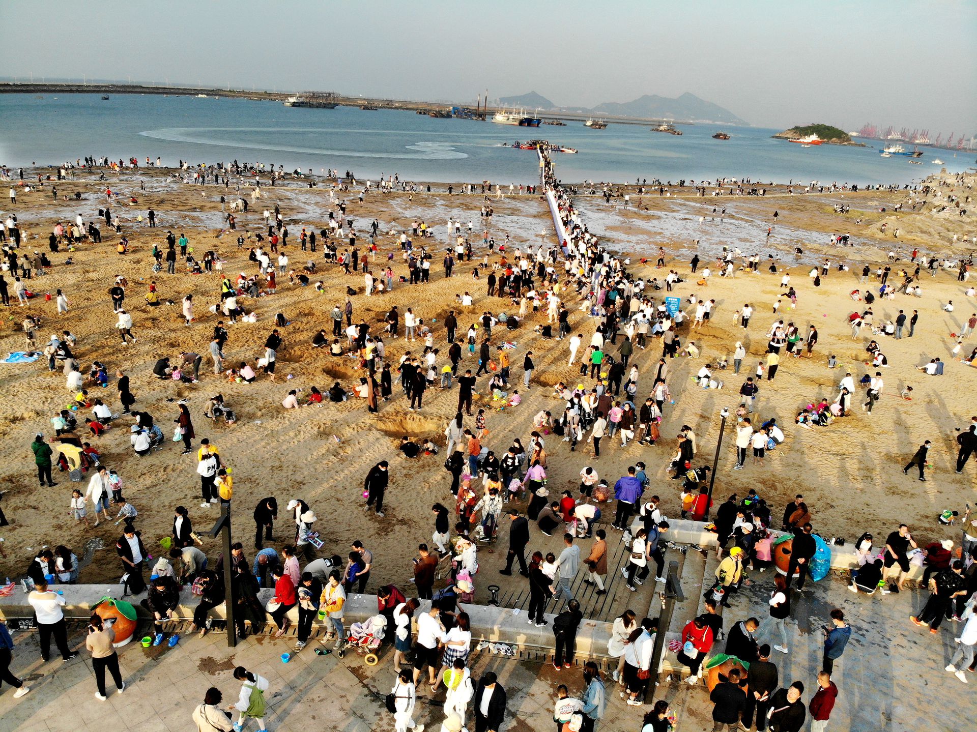2021年5月1日，游客在江苏省连云港市连云区在海一方海滨公园沙滩上游玩（无人机照片）。（视觉中国）
