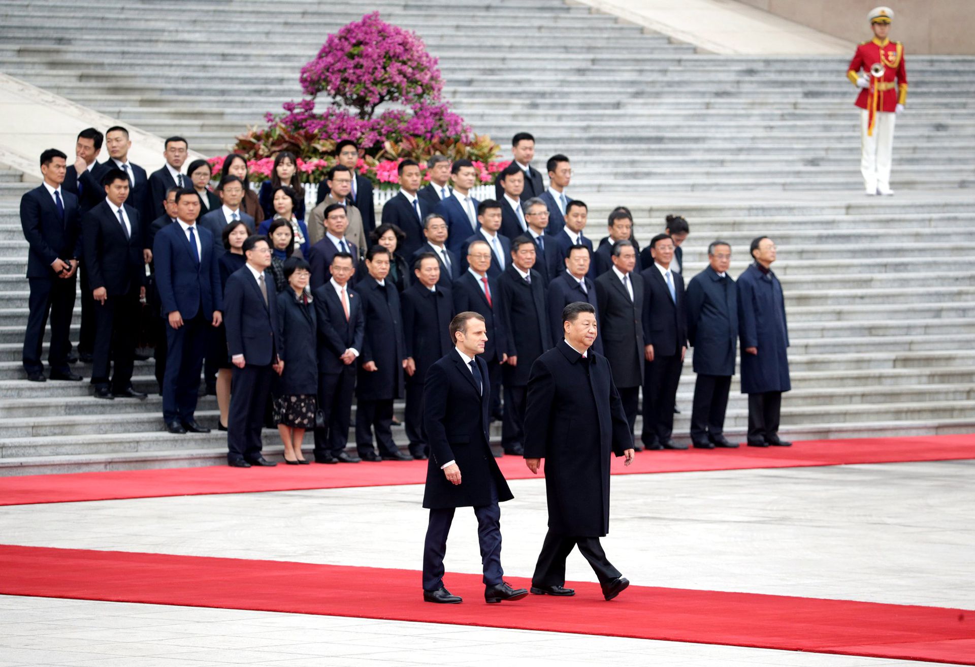 中国国家主席习近平和法国总统马克龙在北京人民大会堂出席欢迎仪式，两人走在红毯上。（Reuters）