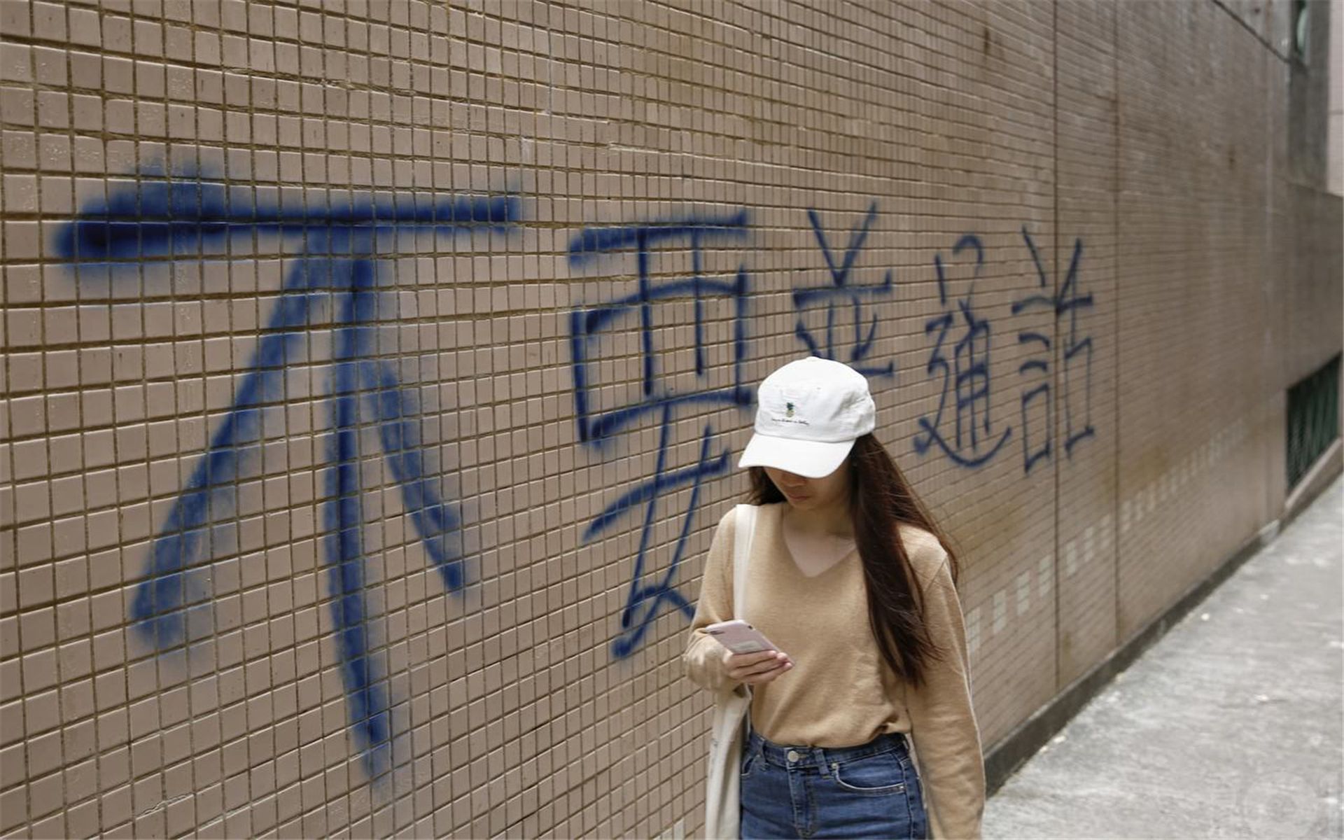 2018年香港浸会大学学生曾提出取消普通话为毕业要求，该校伟衡体育中心旁小路两侧墙壁上出现“不要普通话”的黑色喷漆。（HK01）
