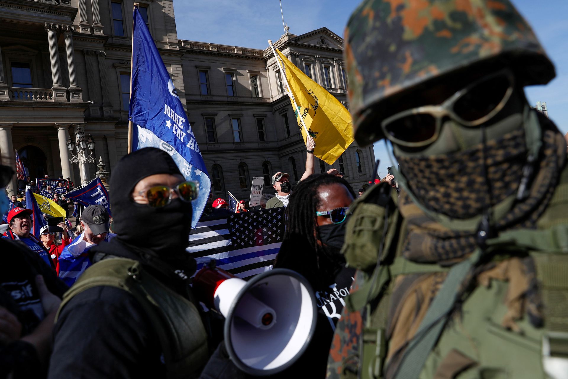 11月7日,美国大选结束后,密歇根州兰辛市扔在计票。当日,特朗普的支持者在该州议会大厦外集会,一位反抗议者身穿迷彩服。(REUTERS) 11月7日,美国大选结束后,密歇根州兰辛市扔在计票。当日,特朗普的支持者在该州议会大厦外集会,一位反抗议者身穿迷彩服。(REUTERS)