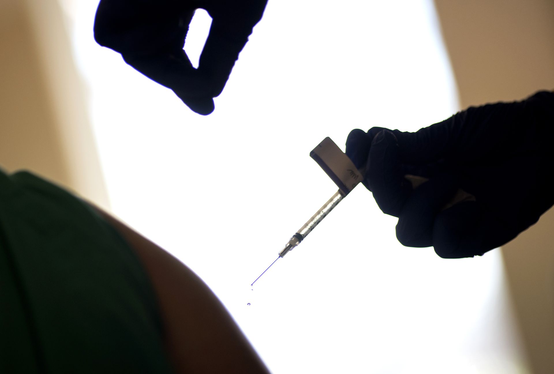 2020年12月15日，罗德岛州一名医护人员在妇女身上注射了辉瑞/BioNTech新冠肺炎疫苗后，注射器中有液滴掉落。（AP）