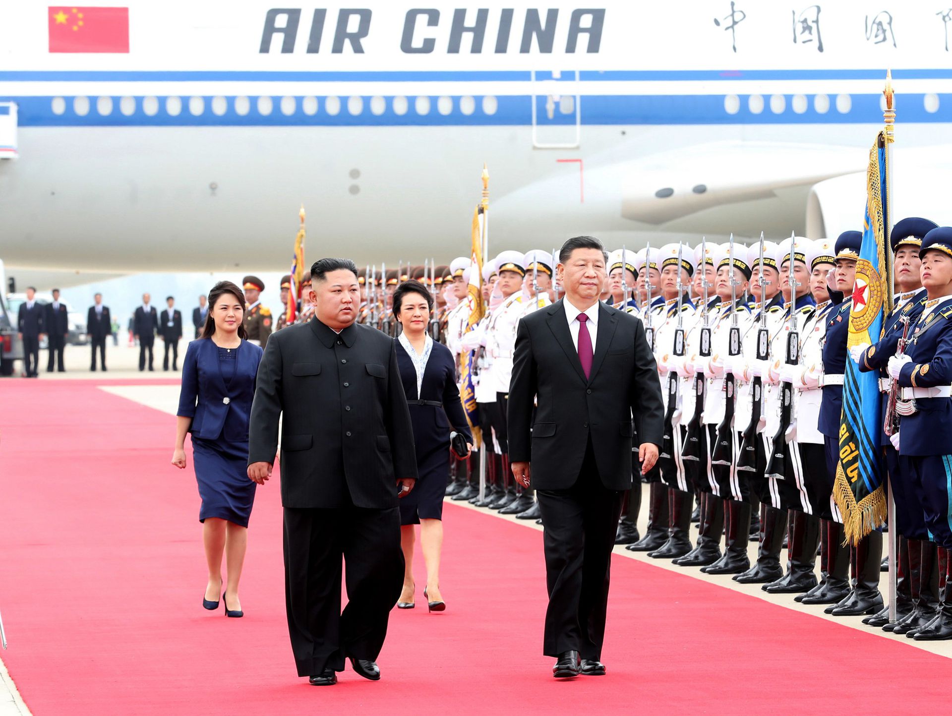 2019年6月20日，金正恩夫妇在平壤国际机场陪同习近平夫妇检阅仪仗队。（新华社）