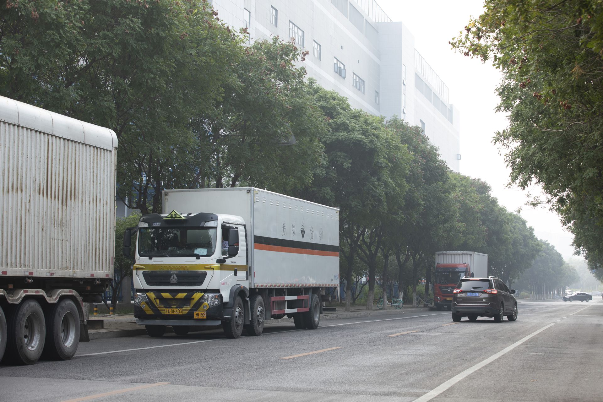 中芯北方积体电路制造（北京）有限公司（以下简称“中芯北方”），成立于2013年7月，是中芯国际与北京市政府共同投资设立的12吋先进制程积体电路制造厂。2020年9月28日，拍摄的中芯北方门外的一条路上，等待进入厂区的货车。（多维新闻）