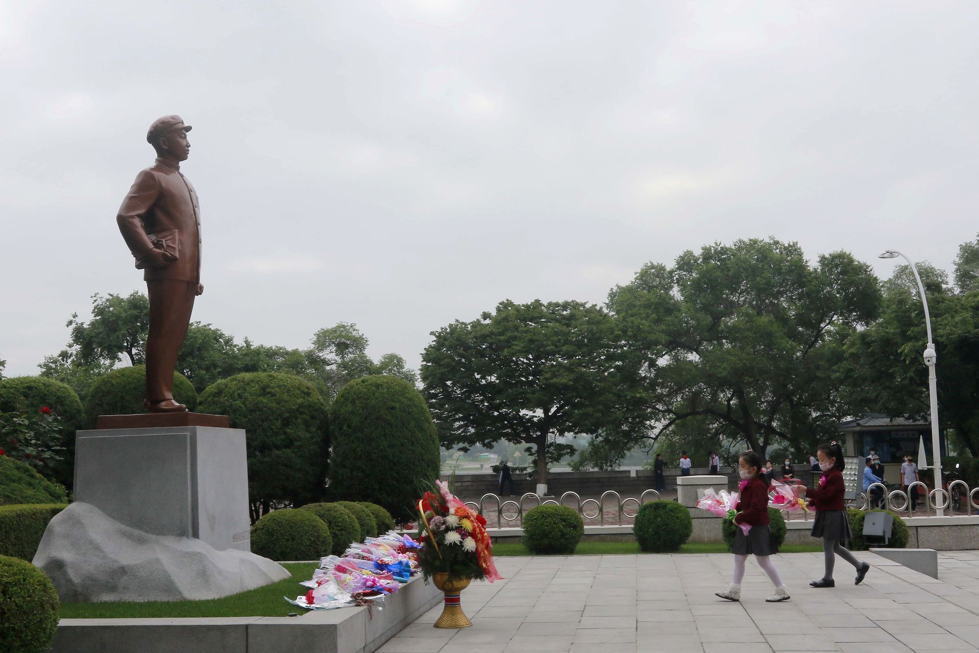 2020年6月3日，在朝鲜平壤的金颂洙小学，戴着口罩的学生们走向前朝已故领导人金日成的铜像敬献鲜花。（AP）