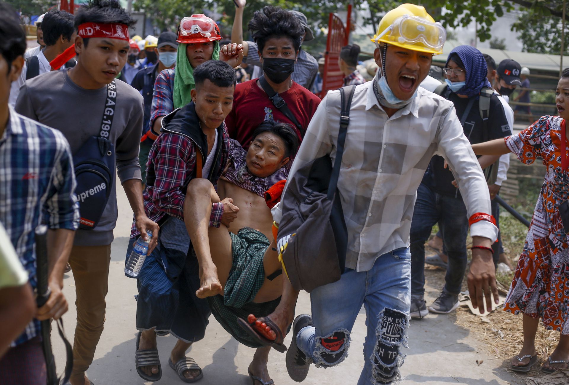 2021年3月14日，缅甸仰光，反政变抗议者在与安全部门发生冲突后抬着一名受伤男子。（AP）