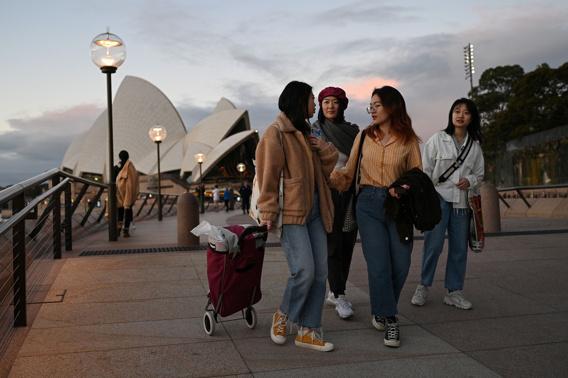 中国留学生Shiyu Bao（右一）和来自中国的同学走在悉尼歌剧院旁的滨海大道上。（人民视觉）