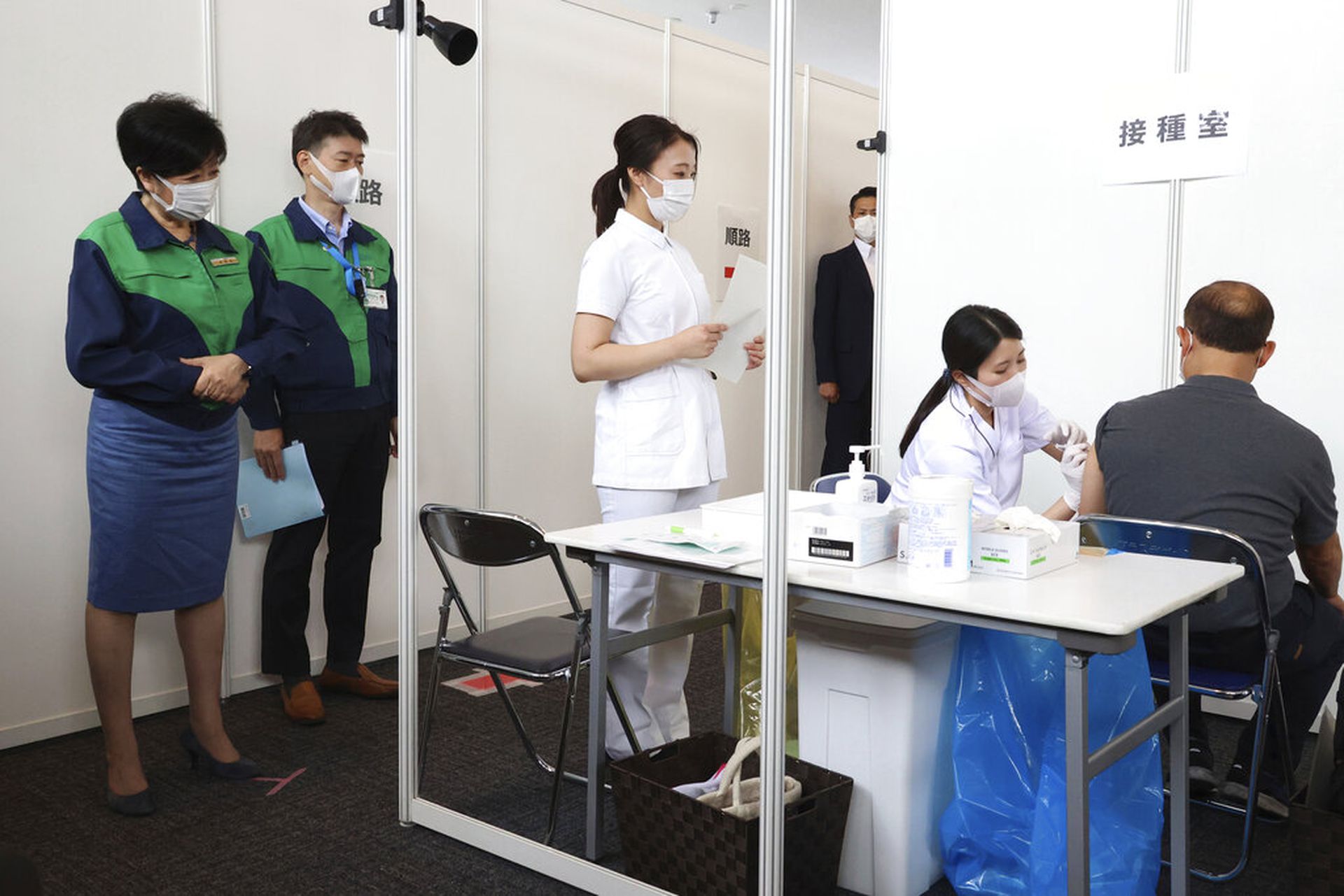 日本新冠肺炎疫情：图为6月18日日本东京都知事小池百合子（左一）在政府办公室观察他人接种疫苗的情况。（AP）