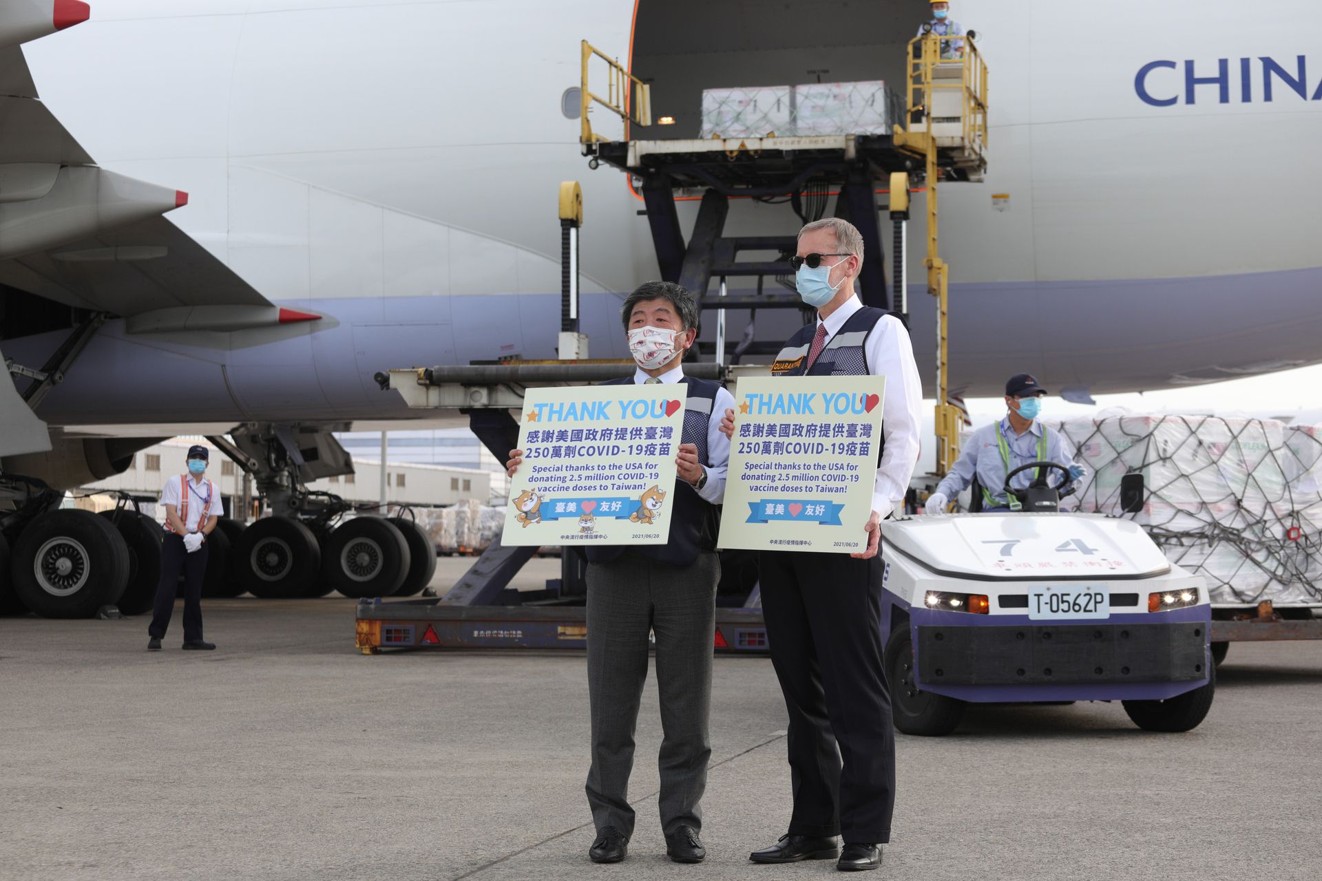 美国援赠台湾250万剂莫德纳疫苗6月20日由华航专机运抵台湾，台湾防疫指挥官陈时中（左）亲赴机场接机，AIT处长郦英杰（右）也到场陪同。（台湾流行疫情指挥中心供图）